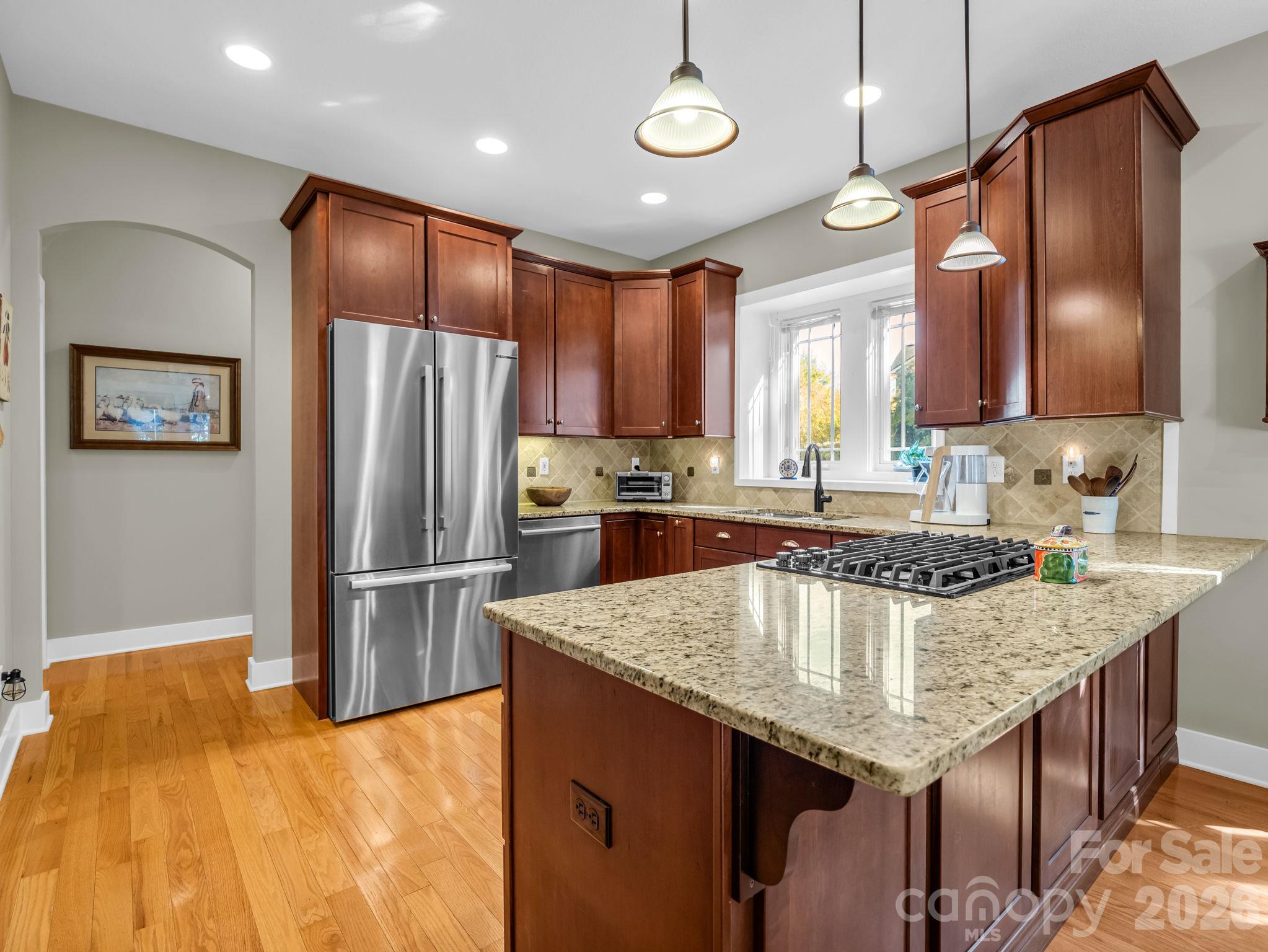 Open kitchen with stainless steel appliances and granite counters - 376 Scarlet Tanager Court, Arden
