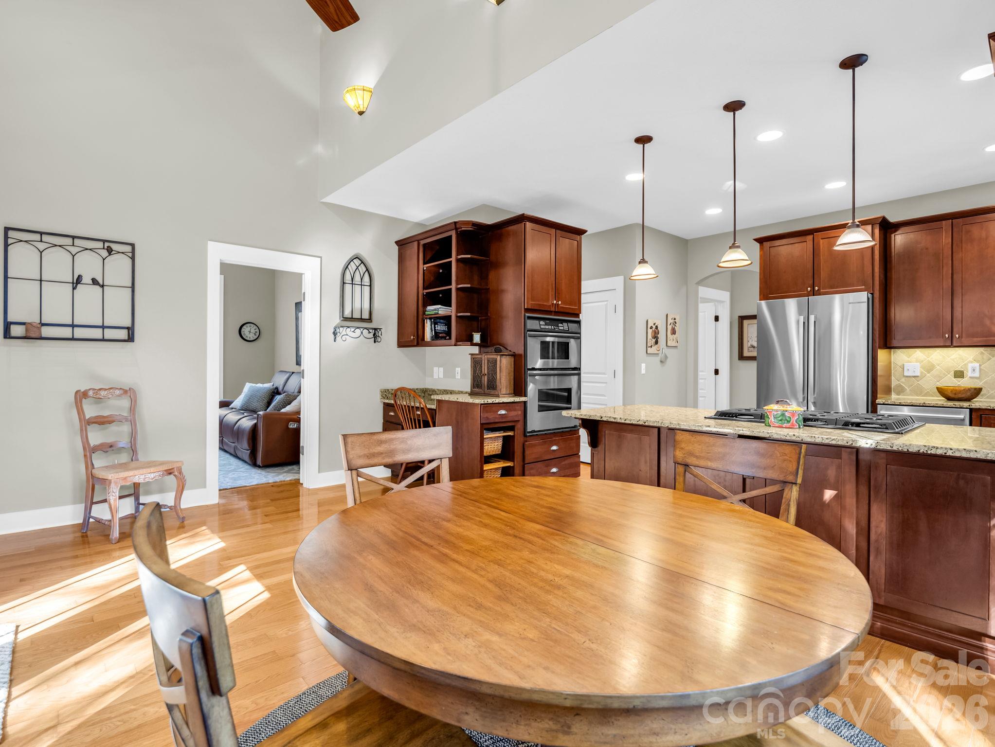 Vaulted breakfast area offers wood beams, view looking into the kitchen, built-in desk - 376 Scarlet Tanager Court, Arden