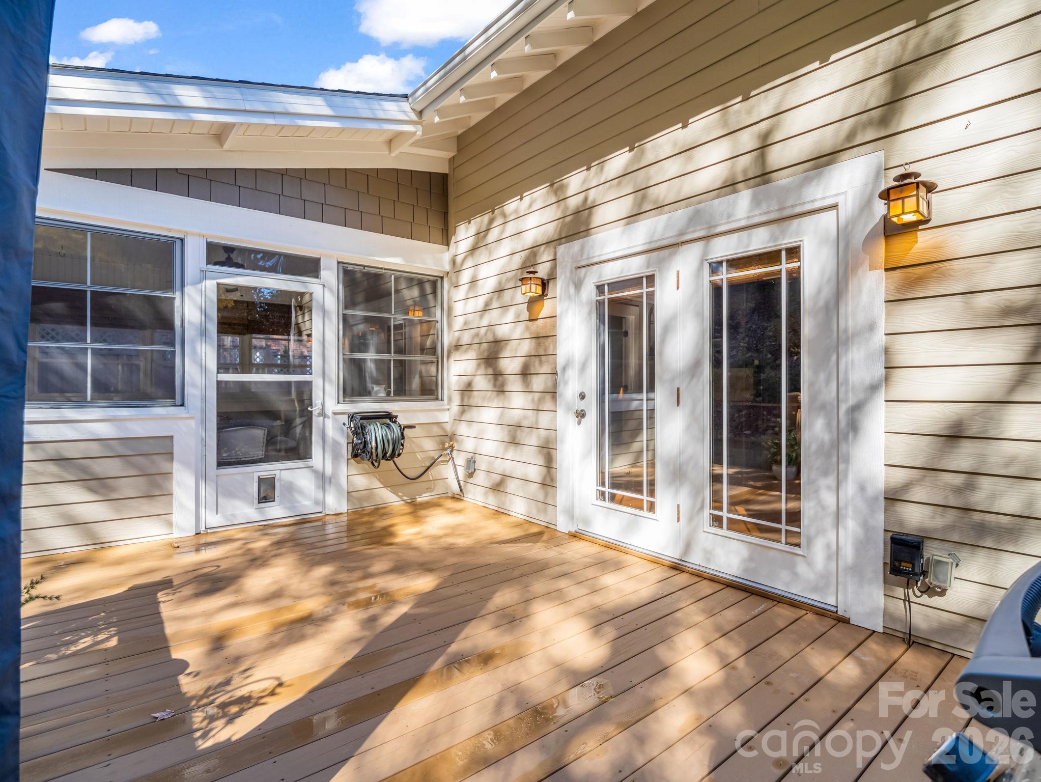 French doors from kitchen/breakfast area lead to back deck, sunroom with Eze-Breeze windows to the left - 376 Scarlet Tanager Court, Arden