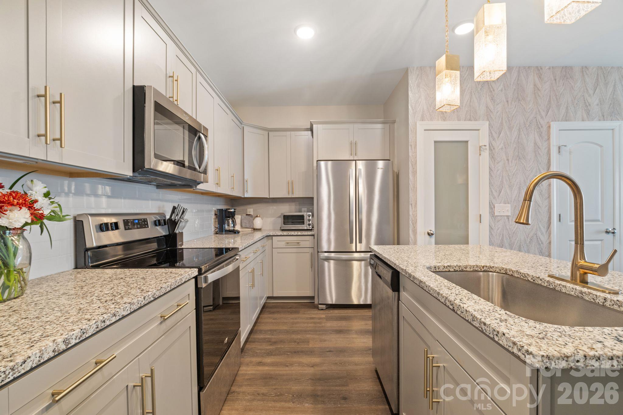 Beautiful kitchen with plenty of cabinet storage, stainless steel appliances, granite counters, oversized sink and an island with seating, perfect for quick meals. - 42 Walnut Springs Drive, Asheville