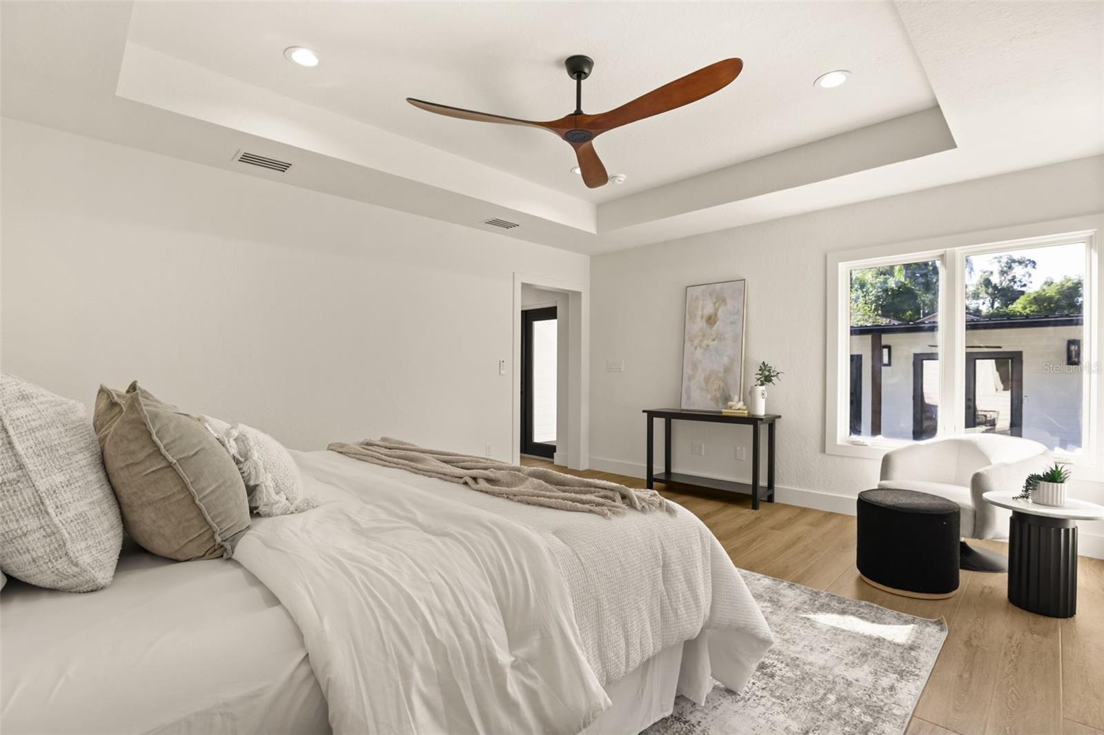 Primary bedroom with recessed ceiling and ceiling fan. - 512 MAYFAIR CIR, ORLANDO
