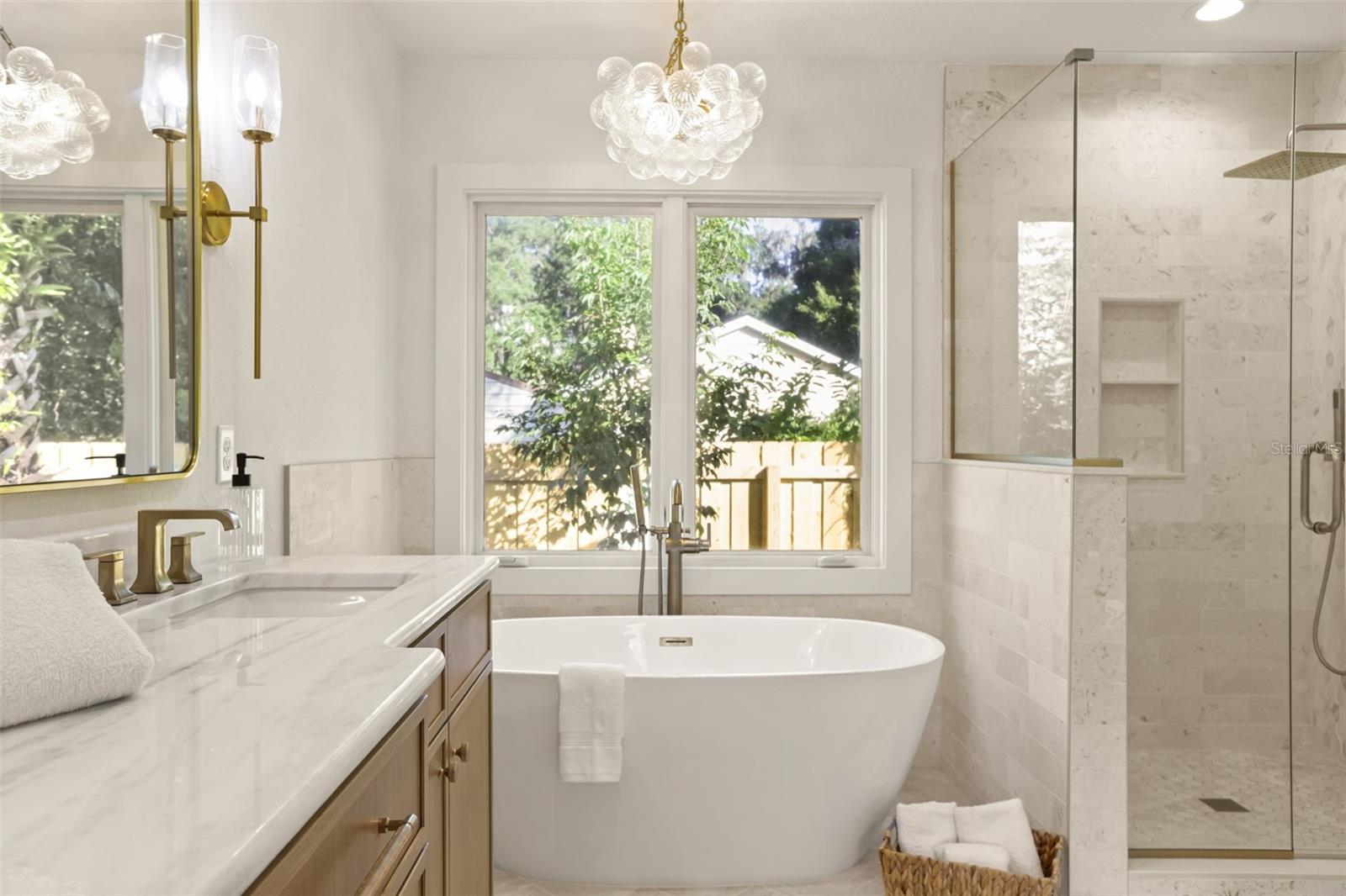 Luxurious soaker tub with a Tabebuia tree just outside and a spa shower. - 512 MAYFAIR CIR, ORLANDO