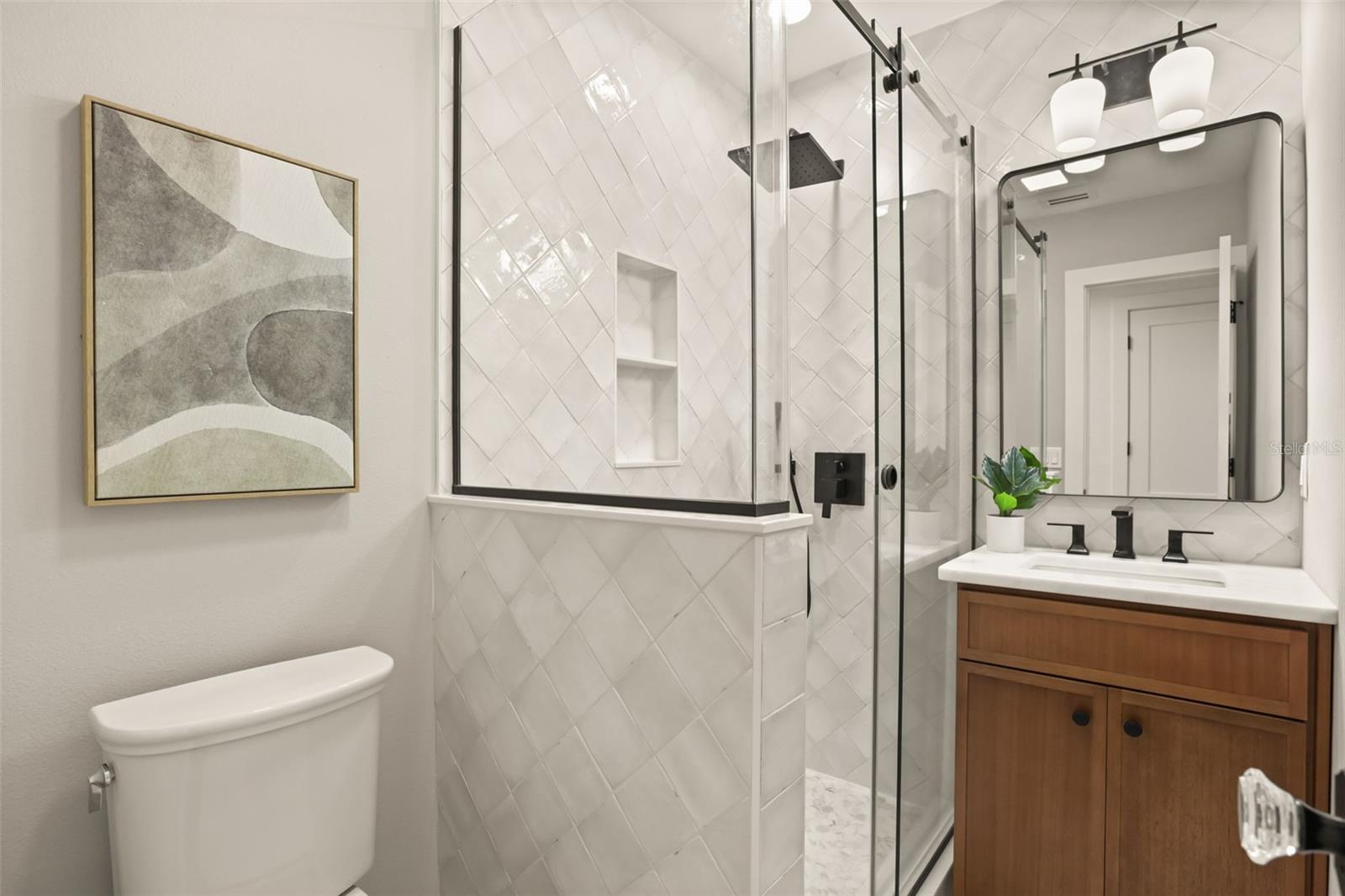 Guest bathroom with tiled shower and beautiful vanity and lighting. - 512 MAYFAIR CIR, ORLANDO