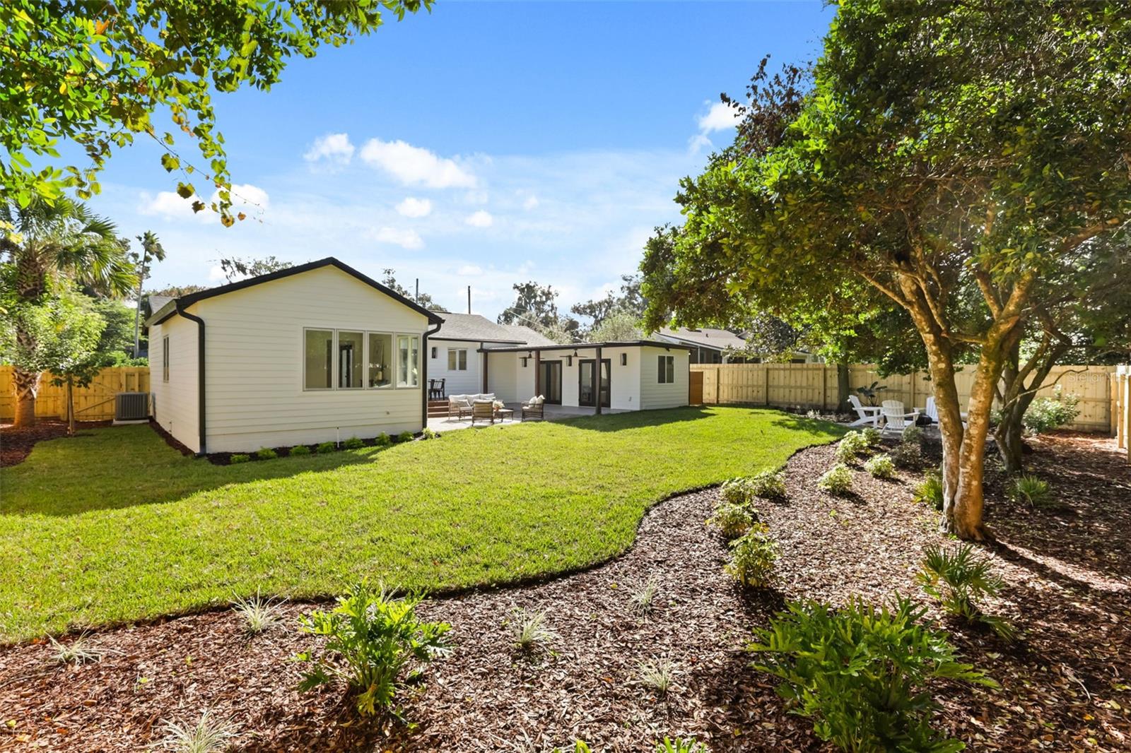 Landscaped backyard with mature trees and shrubs. - 512 MAYFAIR CIR, ORLANDO