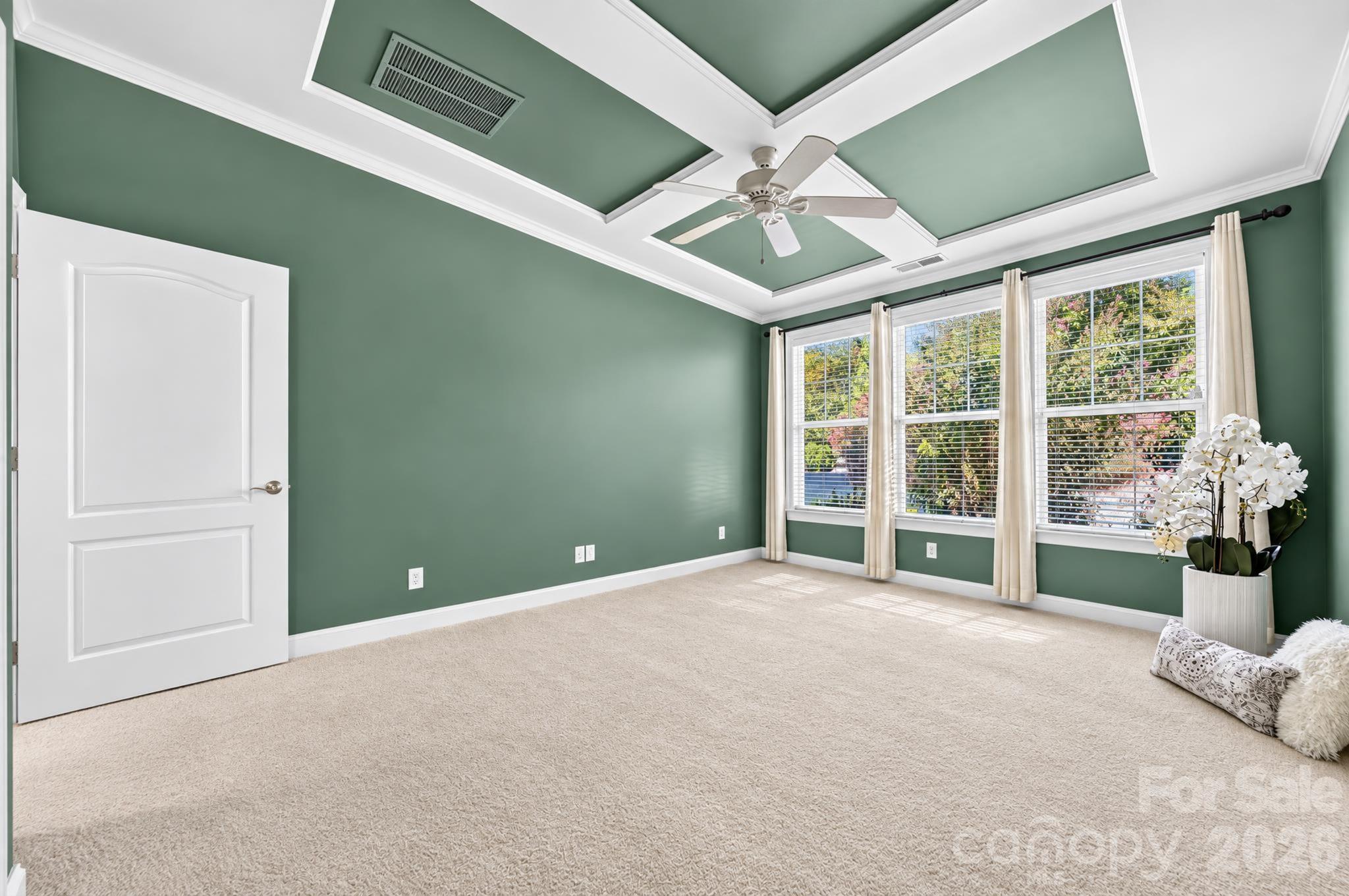 An inviting neutral shade of green helps enhances the beautiful ceiling details and window configuration.  The warmth of a very-nice-quality carpet adds to the quiet, calming effect of the room. - 217 Blossom Ridge Drive, Mooresville
