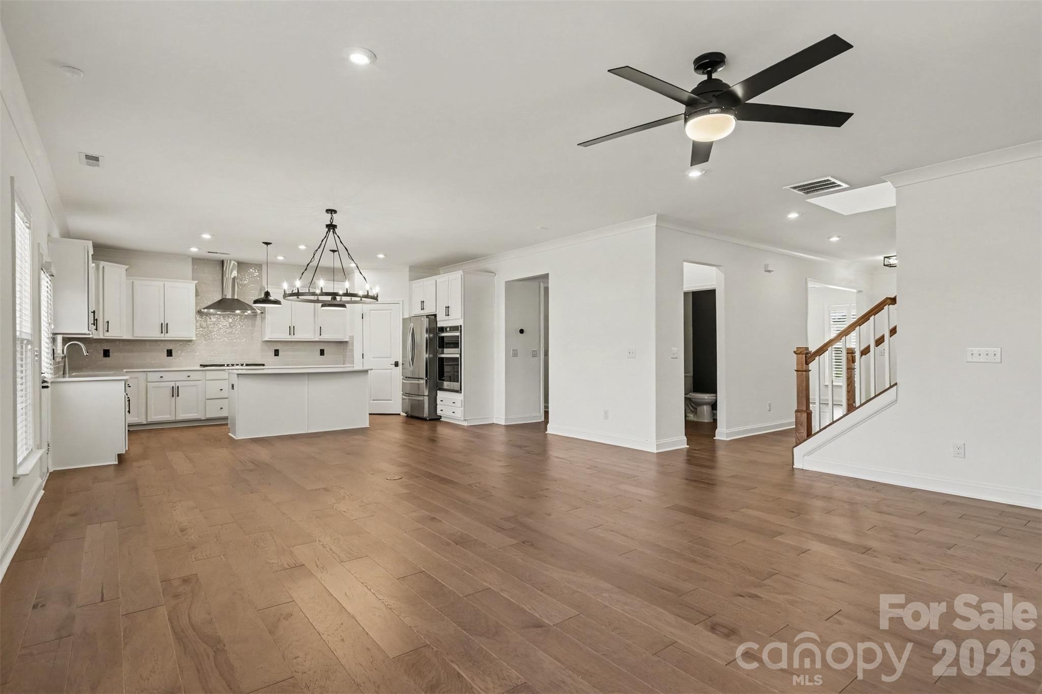 Great Room with Custom Chandelier, LVP Flooring, & Kitchen Space. - 11016 Larkslea Lane, Charlotte