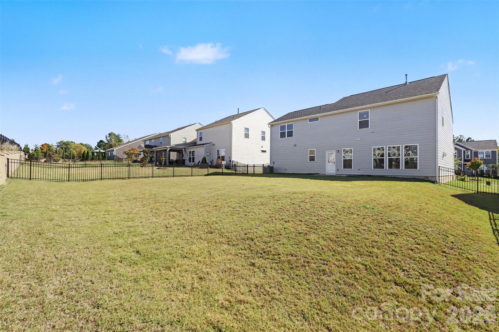 Rear Exterior of Home with Large Fenced Backyard & Concrete Patio. - 11016 Larkslea Lane, Charlotte
