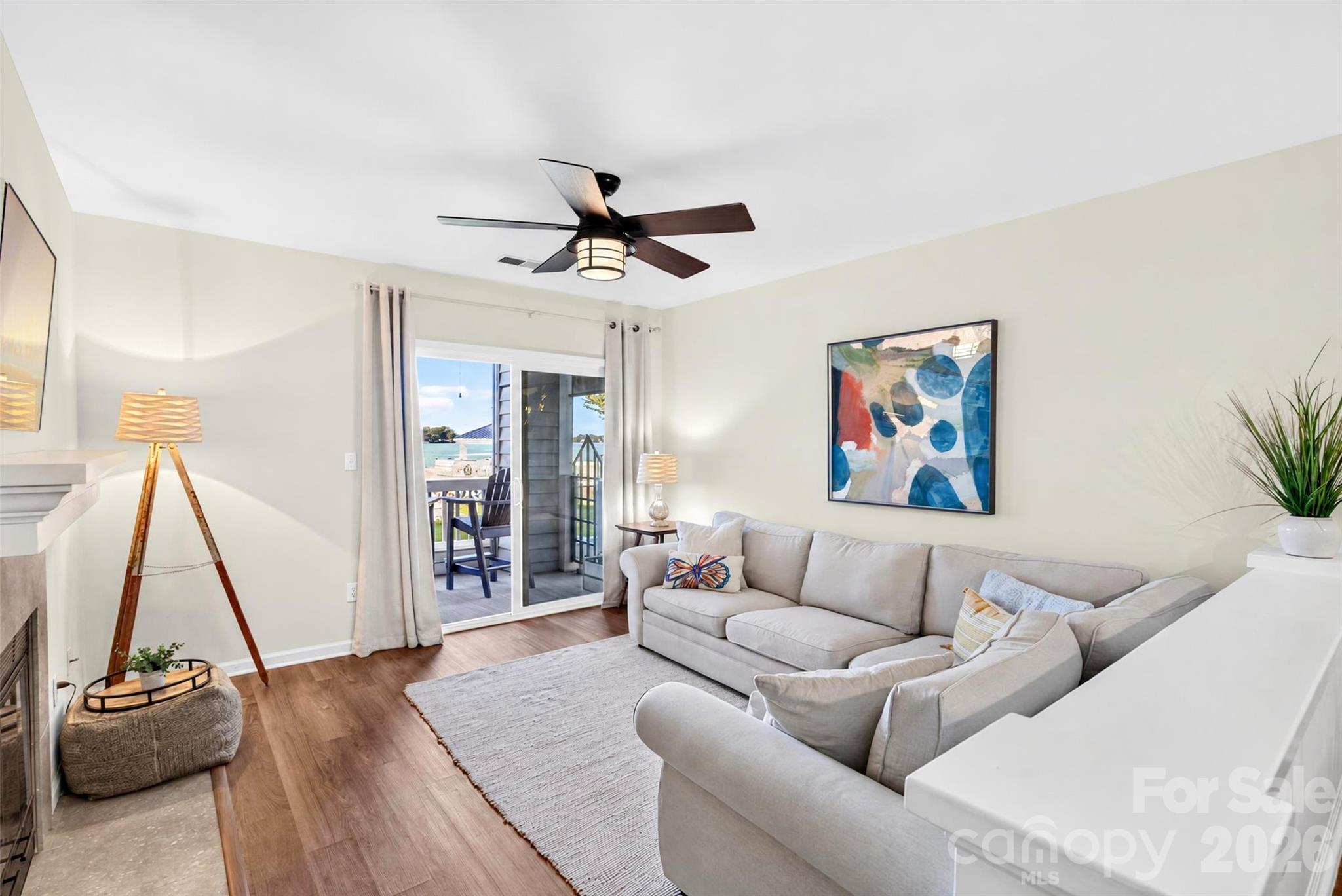 Bright and inviting living room featuring a cozy wood-burning fireplace and, of course, those BREATHTAKING Lake Norman views! The perfect place to relax, unwind, and feel right at home! - 928 Southwest Drive, Davidson