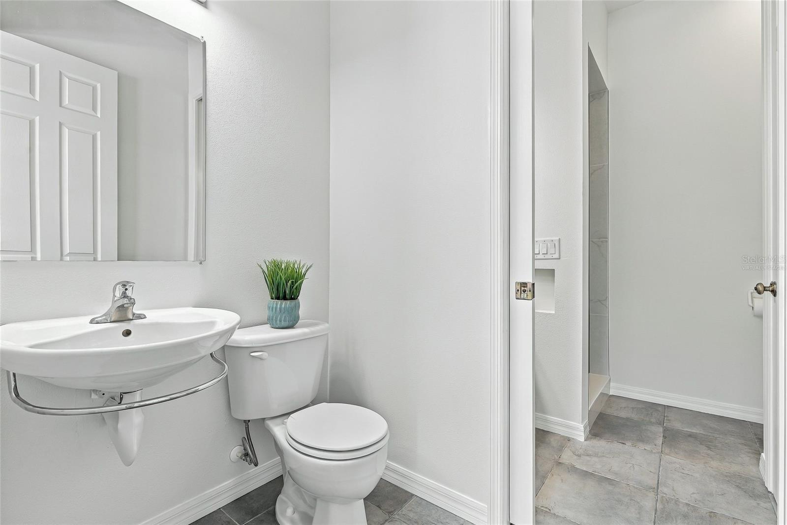 Dually-accessed full bathroom with a half bath easily accessible to the pool. Virtually staged. - 1101 DARLINGTON OAK DR NE, ST PETERSBURG