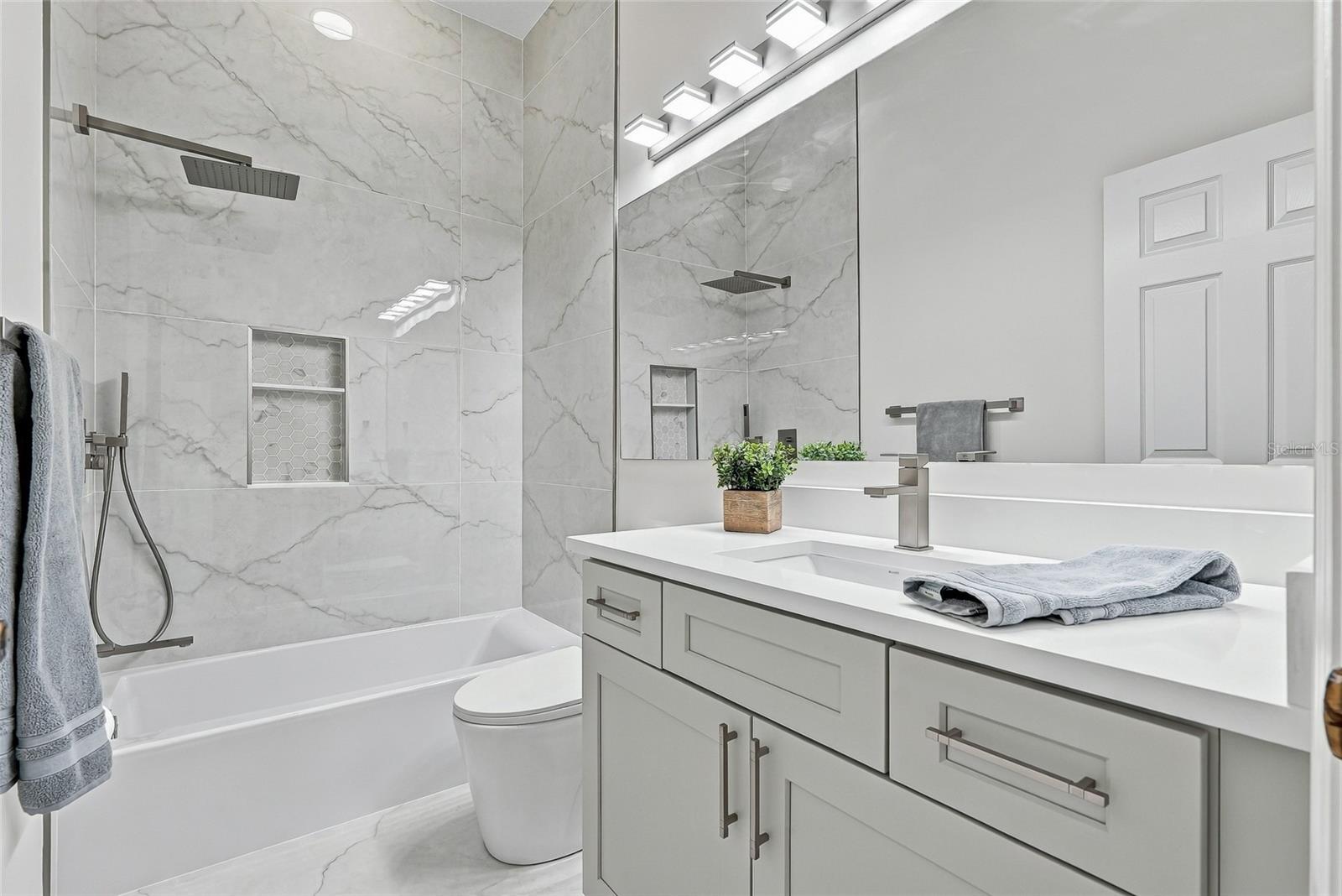 Full hall bath shared by bedrooms 3 and 4. - 1101 DARLINGTON OAK DR NE, ST PETERSBURG