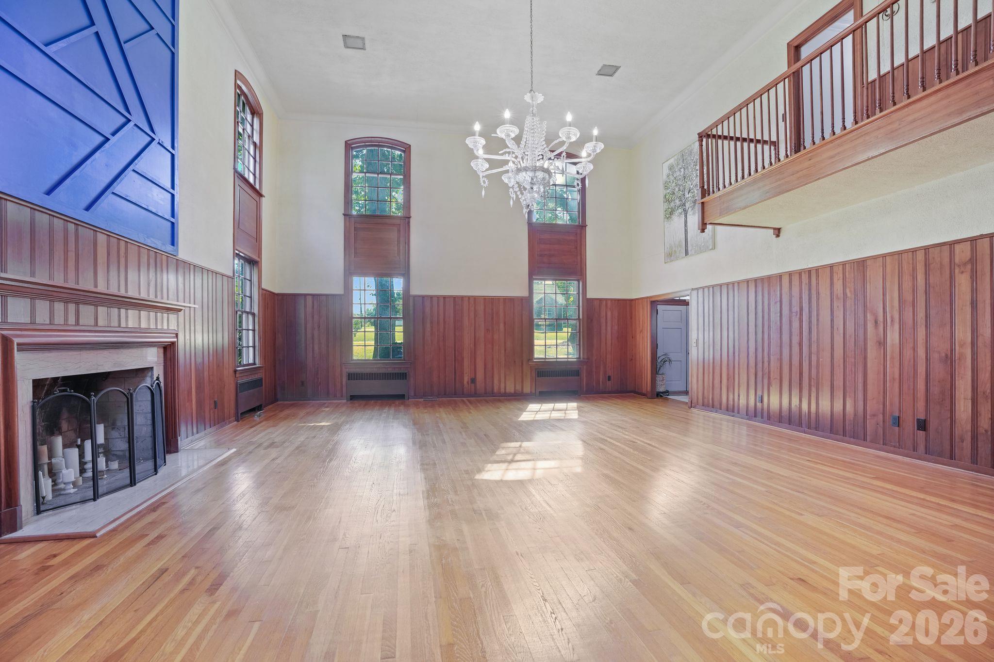 Grand Living Room, 3/4" Thick, Wood Panels Surround, Staircase Ascends from Upstairs, Fireplace, Floor to Ceiling Storm Windows, Hardwood Floor - 319 N Zion Street, Landis