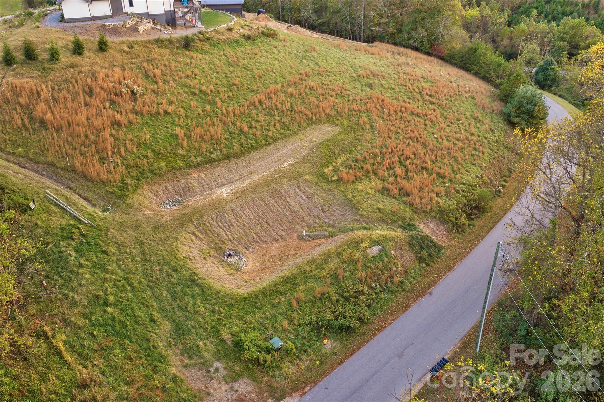 Aerial showing the sloping topography of the lot - 15 French Broad River Way, Asheville