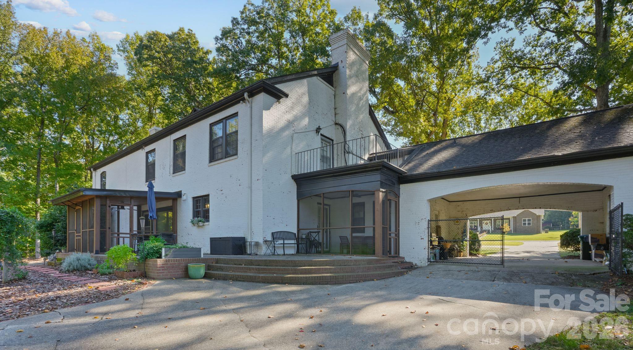 Rear View of the 2 Screened In Porches Balcony and Drive Through the French Porte-Cochere (Portache) - 319 N Zion Street, Landis