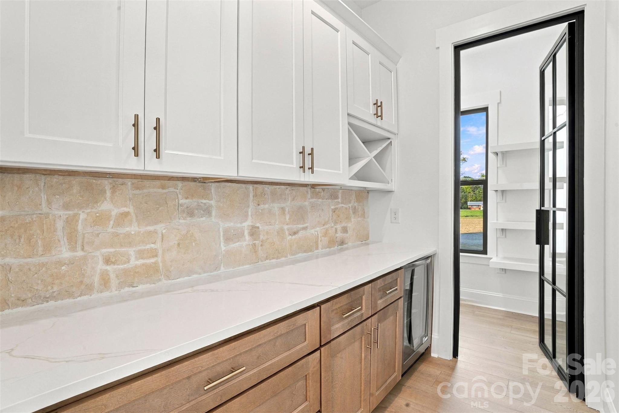 Butler pantry shown with upgraded stonework and black pantry door - 509 Simpson Road, Locust
