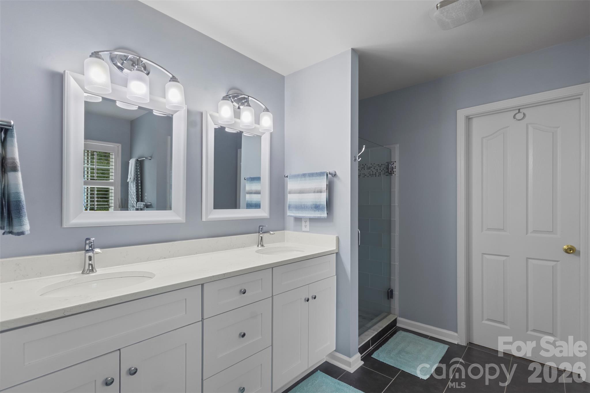 Updated primary bath double sink vanity, lighting fixtures, mirros, tile floors - 18912 Harbor Cove Drive, Cornelius