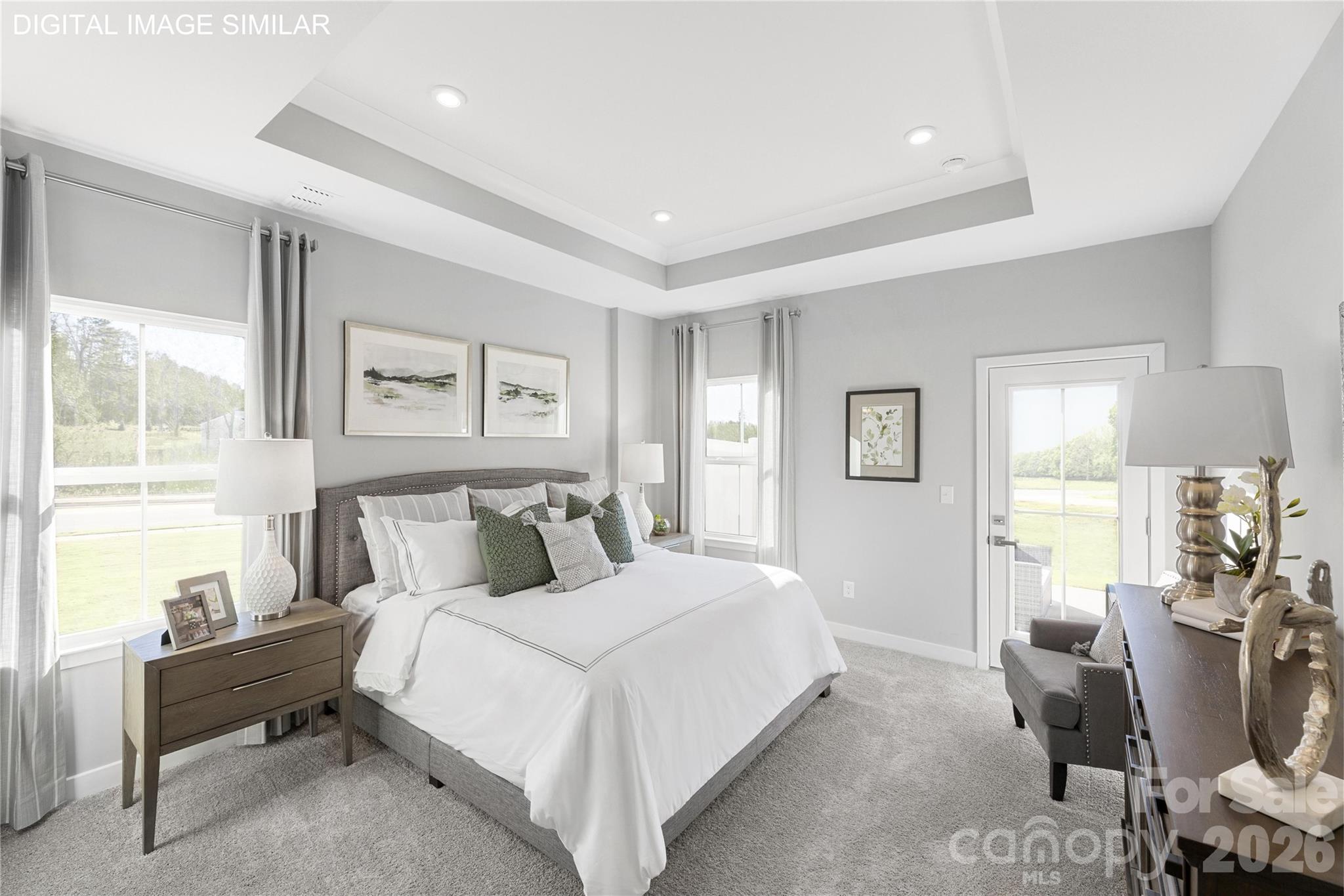 Spacious first-floor primary suite with tray ceiling and abundant natural light—your own private retreat. - 11174 Emerson Landing Drive, Charlotte