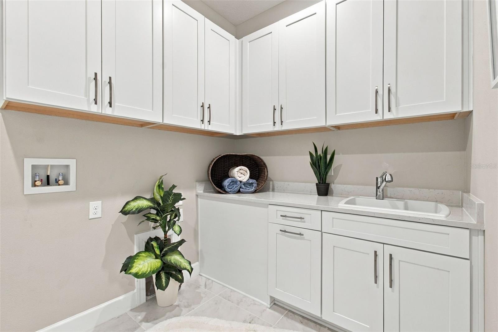 Very large laundry room with upper and lower cabinets and a utility sink - 29749 CASSINO CT, WESLEY CHAPEL