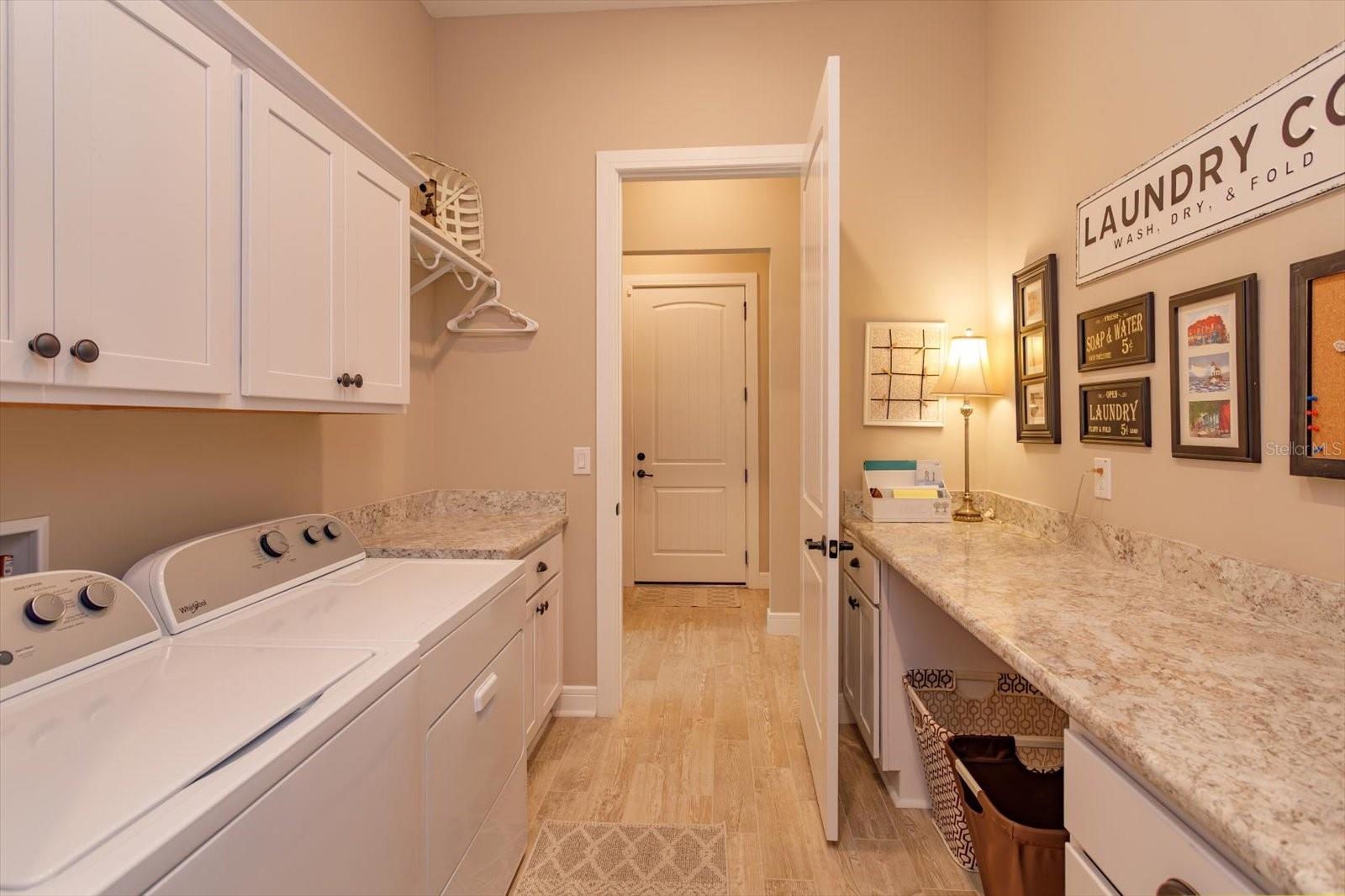 From the Closet or Hallway you can access the Laundry Area with Ample Storage and Countertops for Folding Laundry, Crafts or Projects. - 5663 SW 92ND AVENUE RD, OCALA