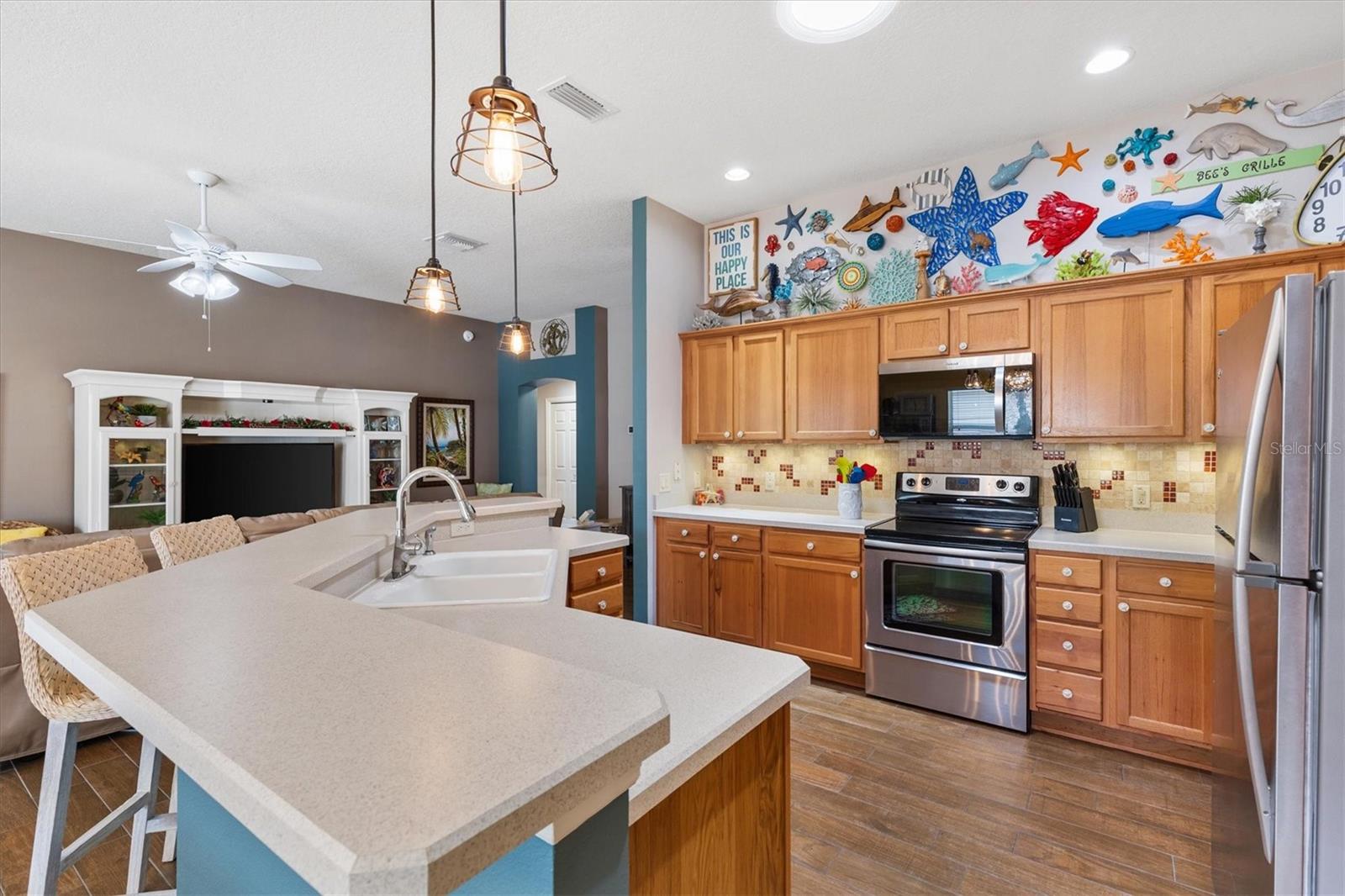 KITCHEN WITH LOTS OF CABINETS AND BAR STOOLS - 2398 FLATWOOD ST, THE VILLAGES