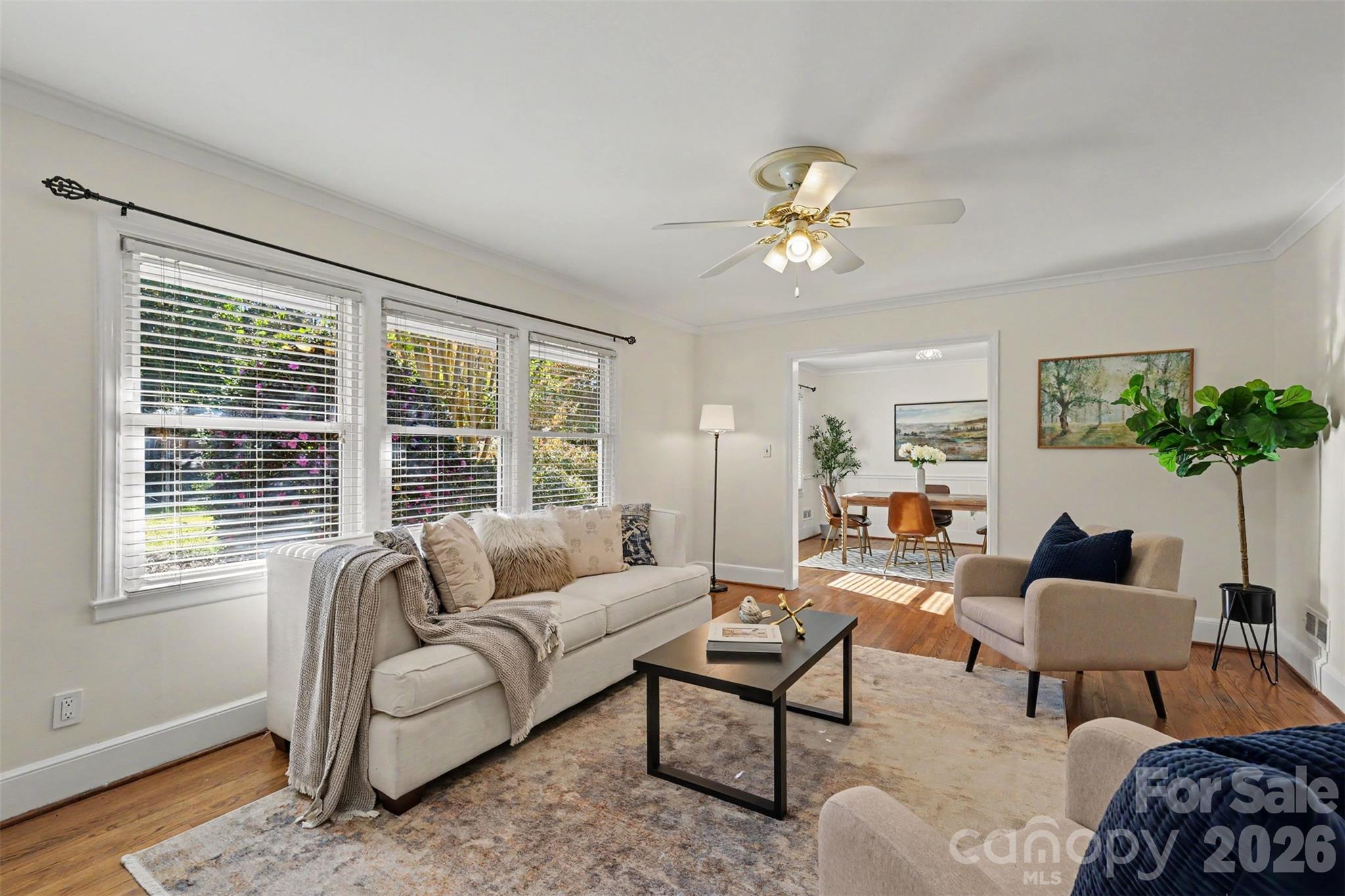 Sunlight pours through the windows, creating a bright, welcoming living room with beautiful hardwood floors. - 407 Pine Street, Fort Mill