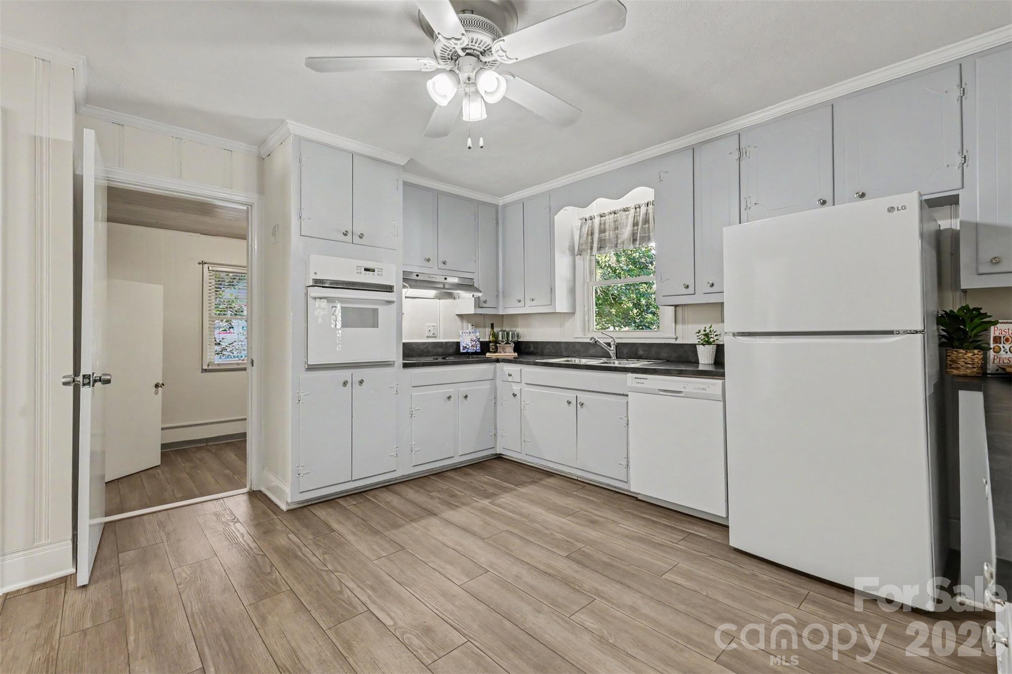 Another view of the kitchen, featuring extensive cabinetry and a window overlooking the greenery. - 407 Pine Street, Fort Mill