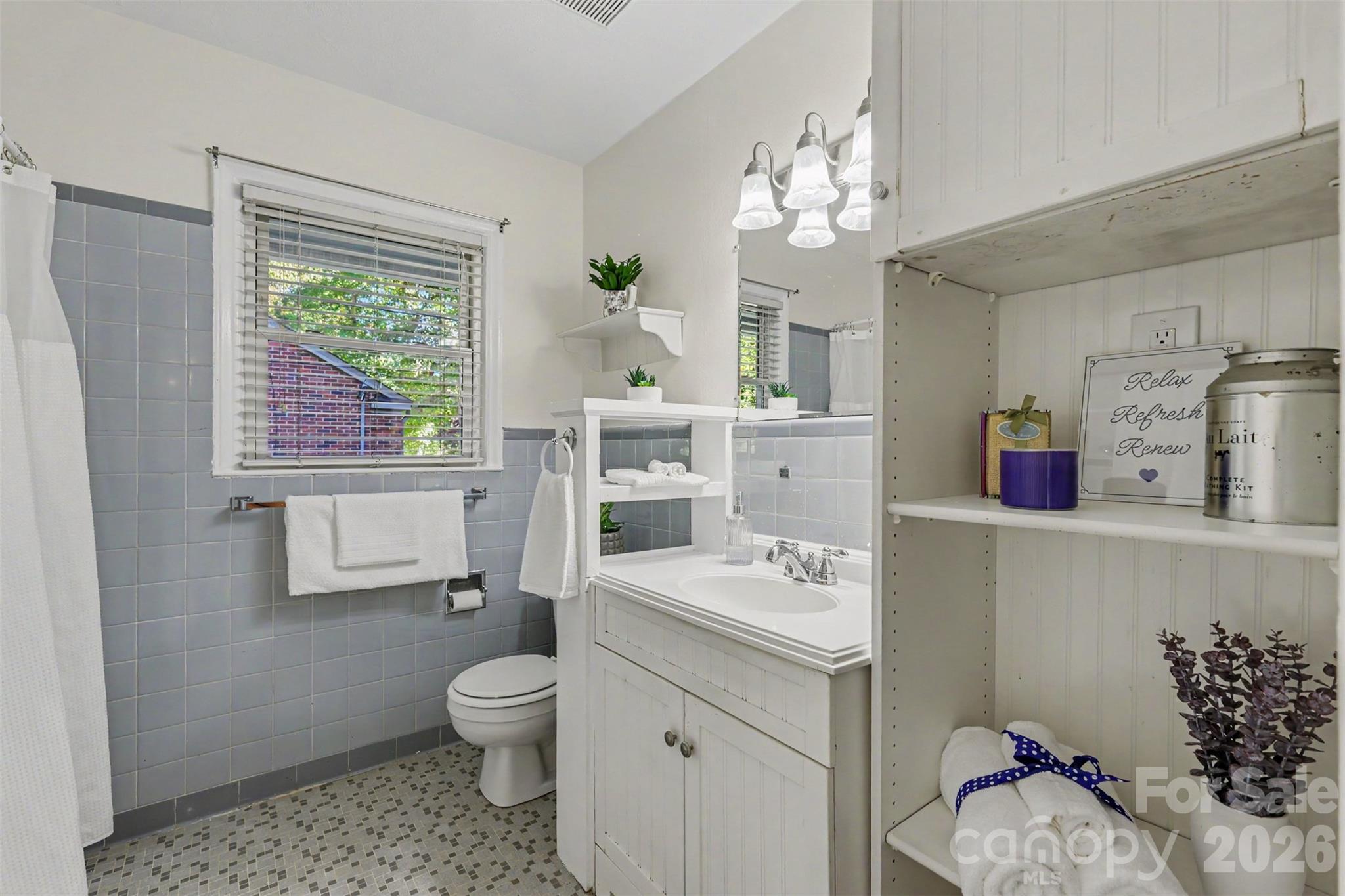Full bathroom with classic tile, built-in storage, and natural light. - 407 Pine Street, Fort Mill