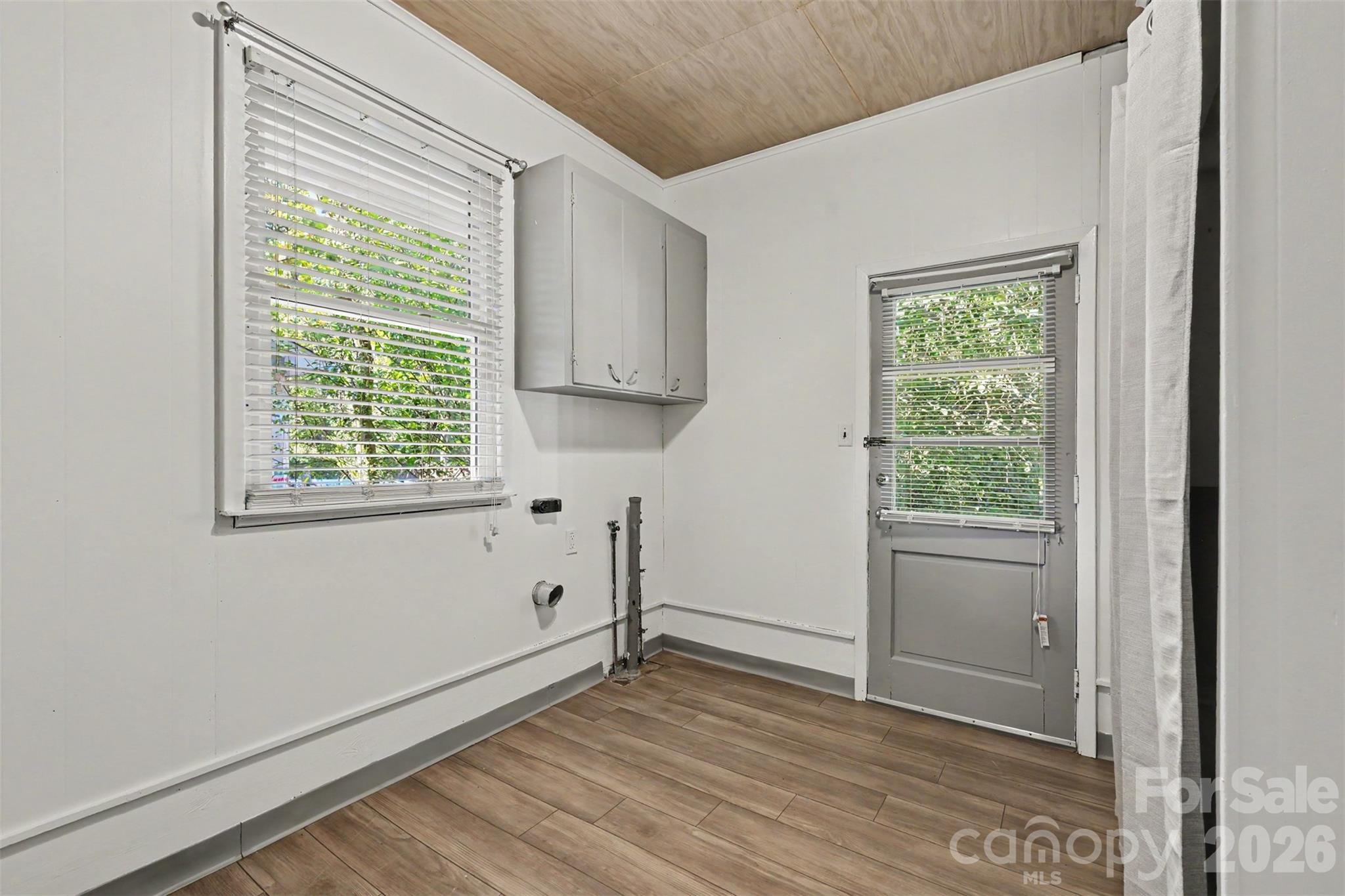 Dedicated laundry room with built-in cabinetry for storage and organization, plus convenient access to the outdoors. - 407 Pine Street, Fort Mill
