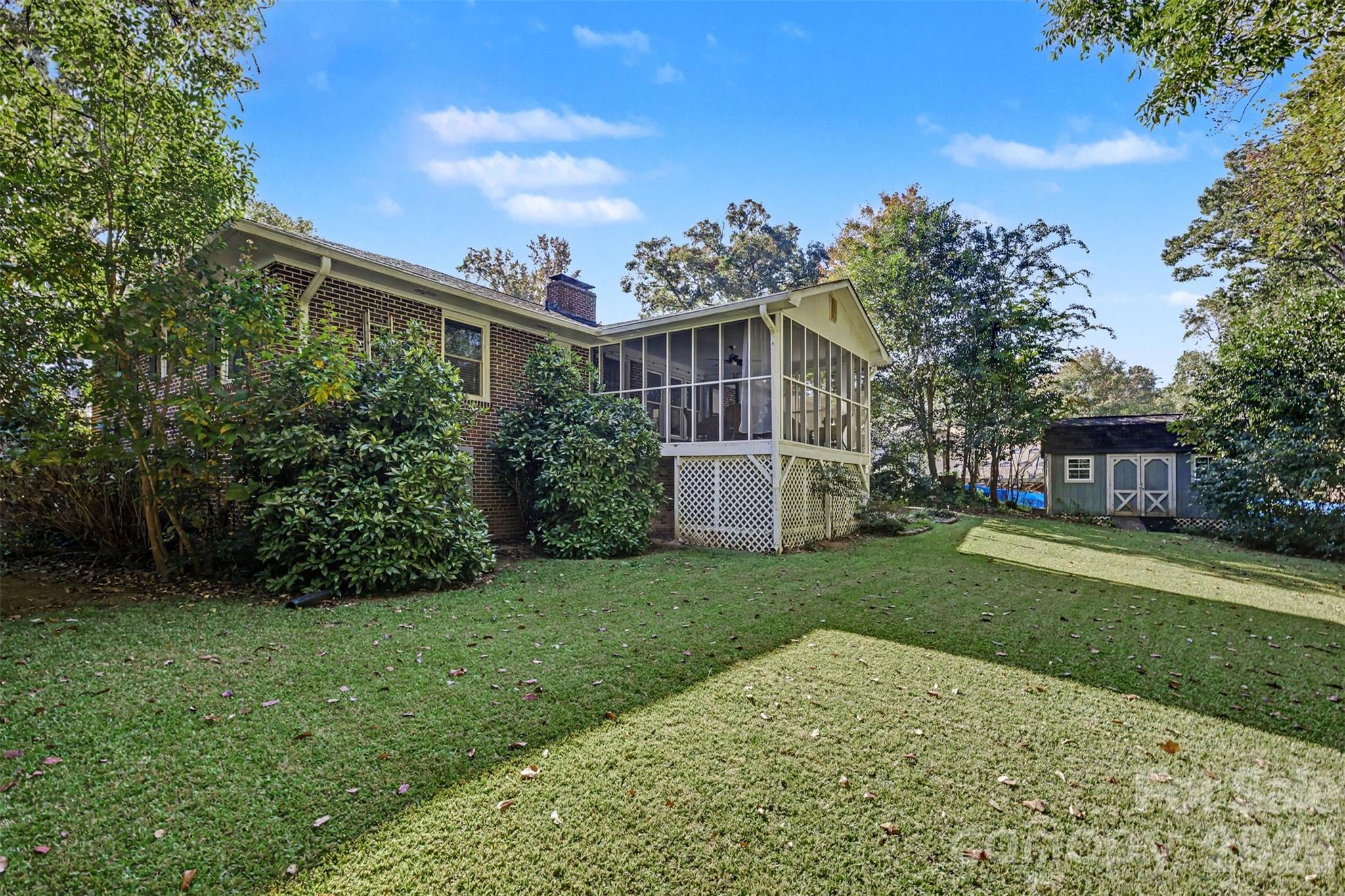 Mature landscaping and an expansive lawn create a peaceful backyard setting. - 407 Pine Street, Fort Mill