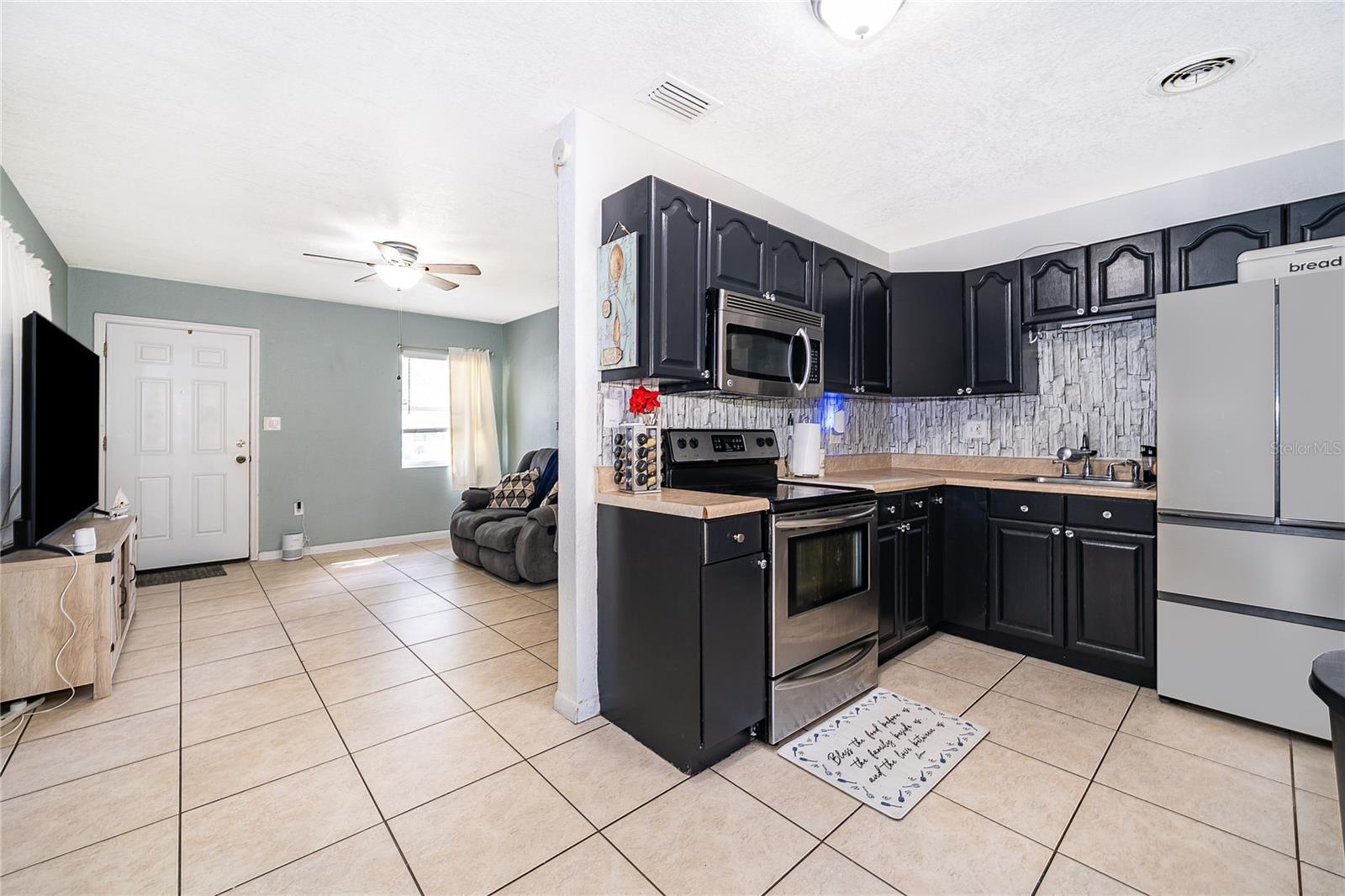 Enjoy preparing meals in this functional kitchen featuring dark cabinetry, ample countertop space, and easy access to the dining area. - 800 DORADO AVE, ORLANDO