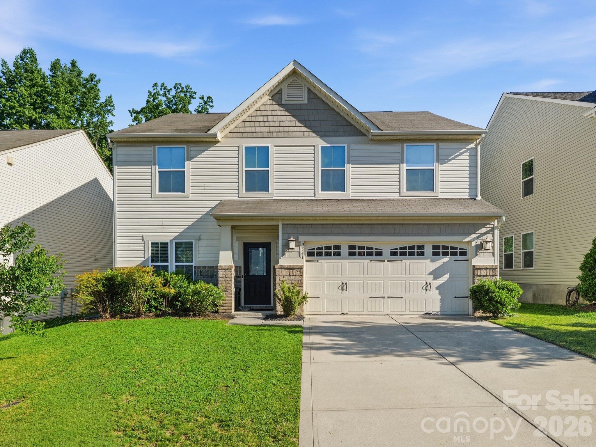 Front exterior: Two-story home in The Farm at Riverpointe with a covered front entry, two-car garage, and concrete driveway. - 3341 Linetender Drive, Davidson