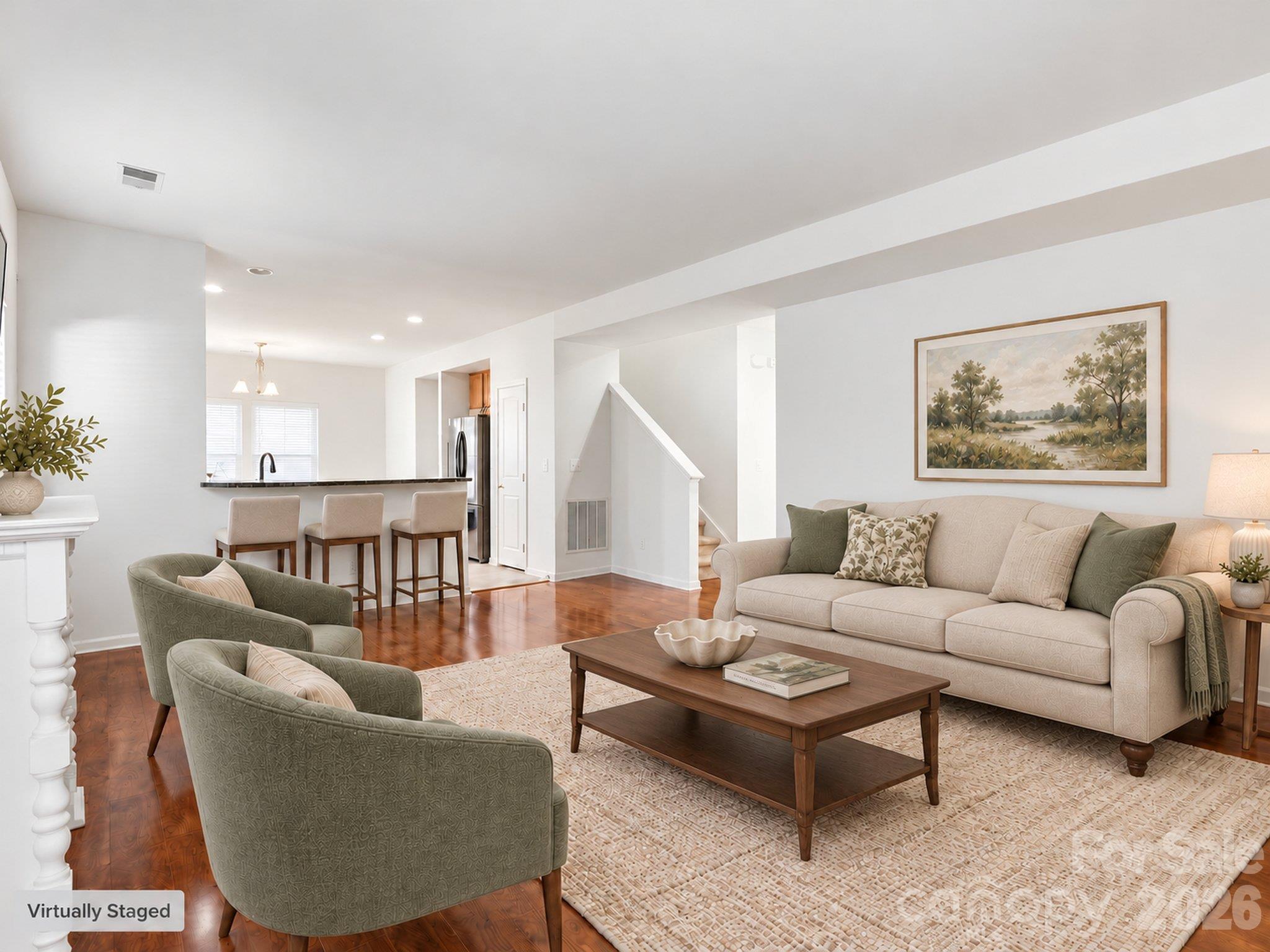 Virtually staged living room illustrates space for conversation and relaxing, with a raised breakfast bar connecting the room to the kitchen. Furnishings and décor digitally added. - 3341 Linetender Drive, Davidson