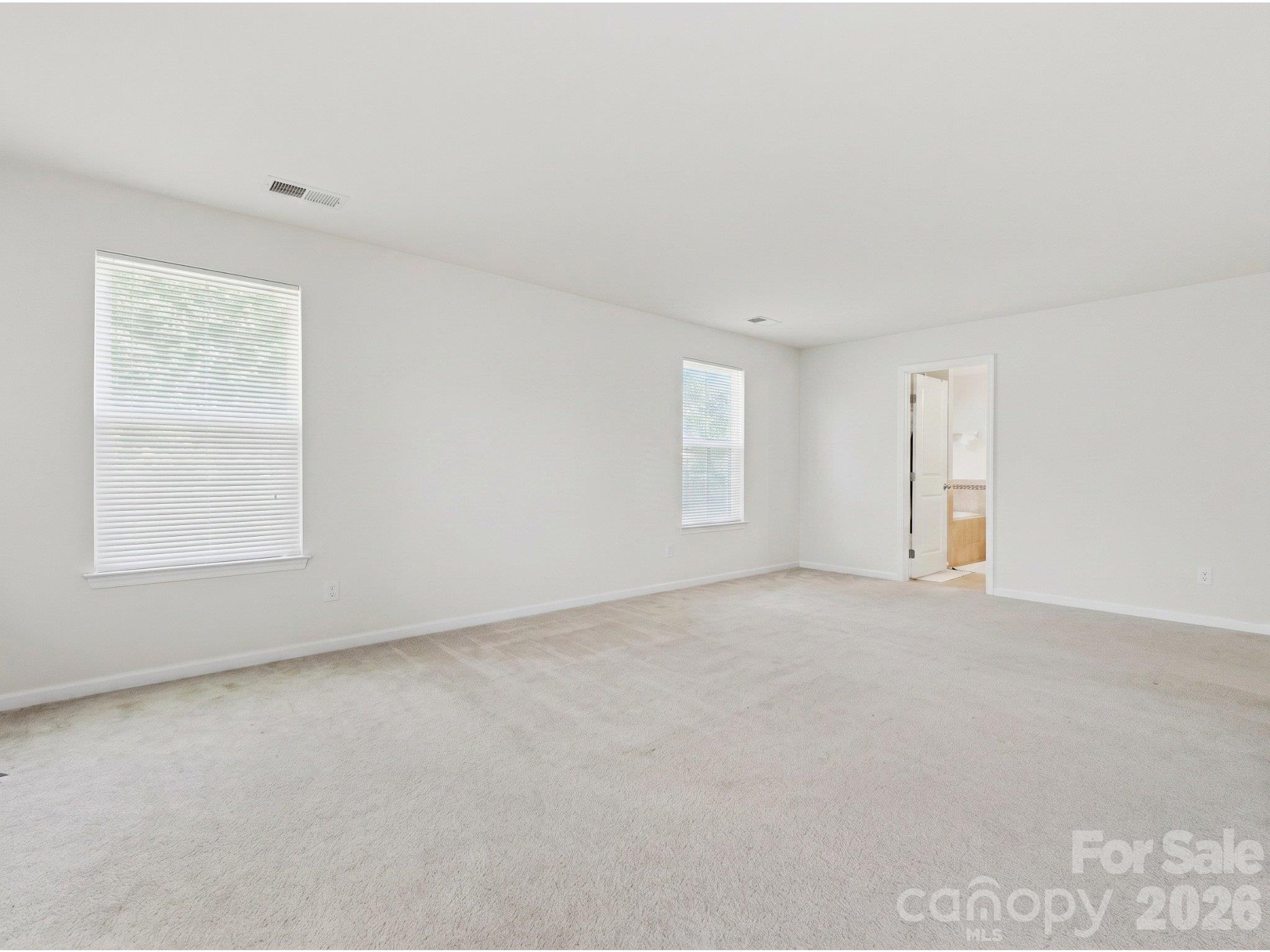 Primary bedroom: Alternate view showing the connection to the ensuite bath and the bedroom's generous floor space. - 3341 Linetender Drive, Davidson
