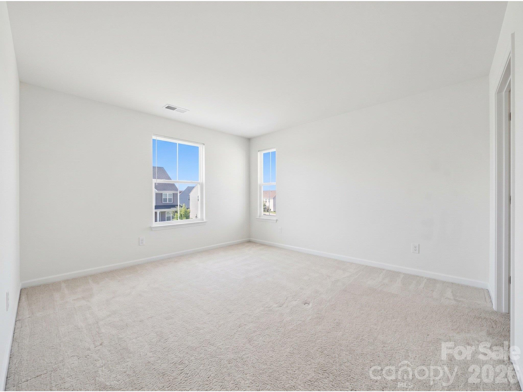 Bedroom three: Upstairs bedroom with two windows, carpeting, and neutral finishes, offering flexibility for sleeping, guests, or a home workspace. - 3341 Linetender Drive, Davidson