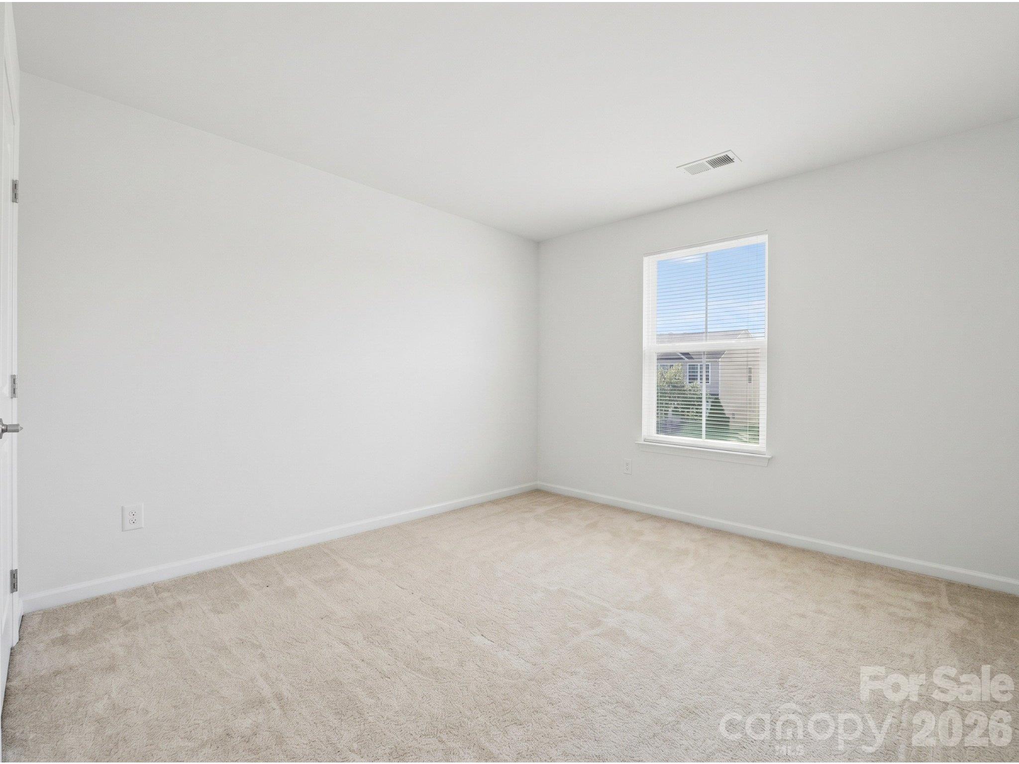 Bedroom two: Upstairs bedroom with carpeting, neutral finishes, and natural light. Flexible space for a bedroom, guest room, or home workspace. - 3341 Linetender Drive, Davidson