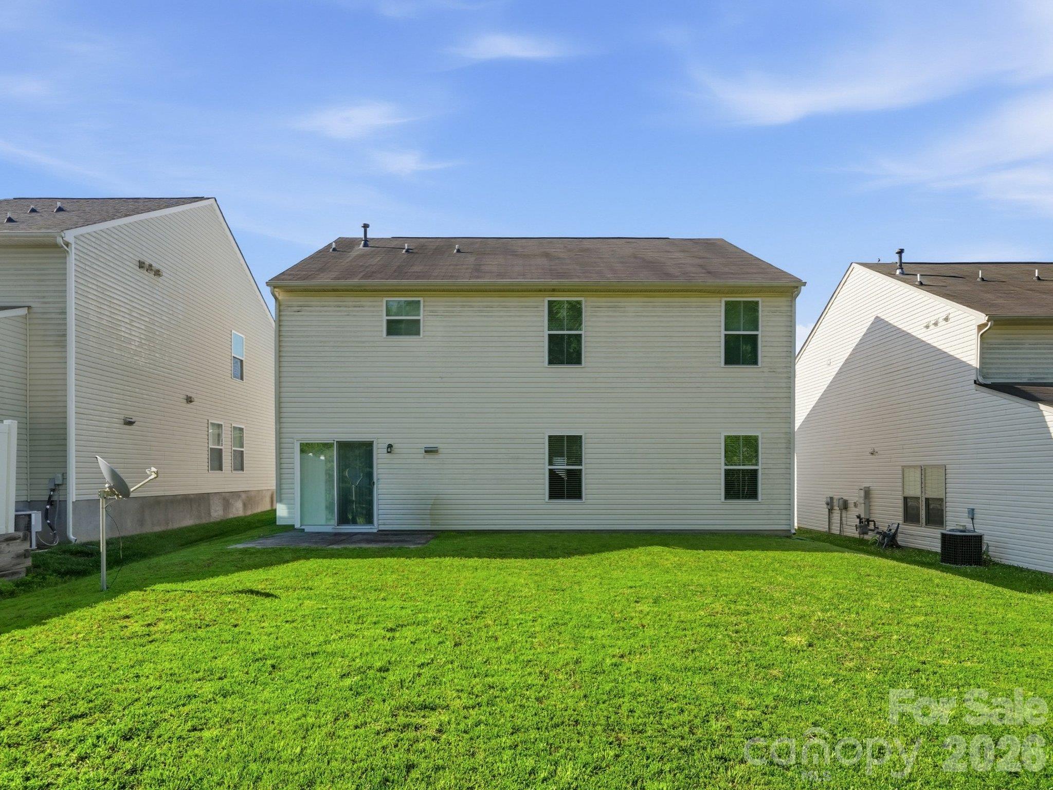 Rear exterior with a backyard lawn and patio accessible from the kitchen and casual dining area. - 3341 Linetender Drive, Davidson