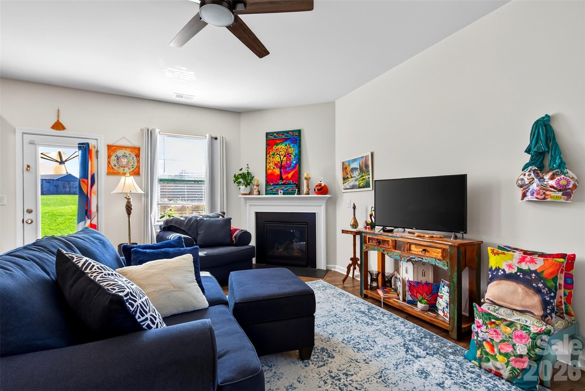 The spacious living room features a cozy gas-log fireplace and doors leading to the backyard, creating a comfortable space for relaxing and entertaining. - 313 Tavernier Lane, Candler