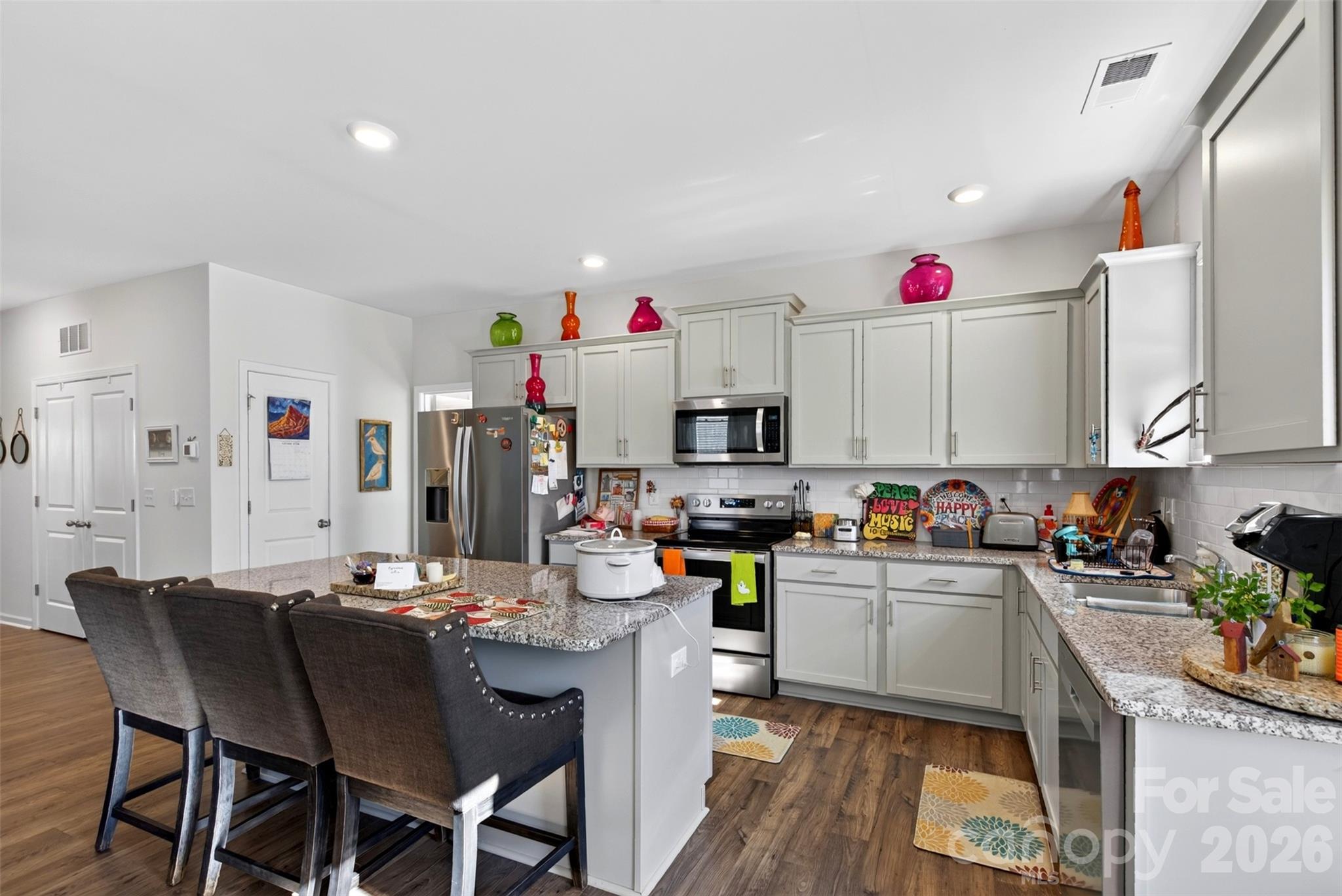 The open kitchen features beautiful granite countertops and a functional layout, perfect for everyday living and entertaining. - 313 Tavernier Lane, Candler