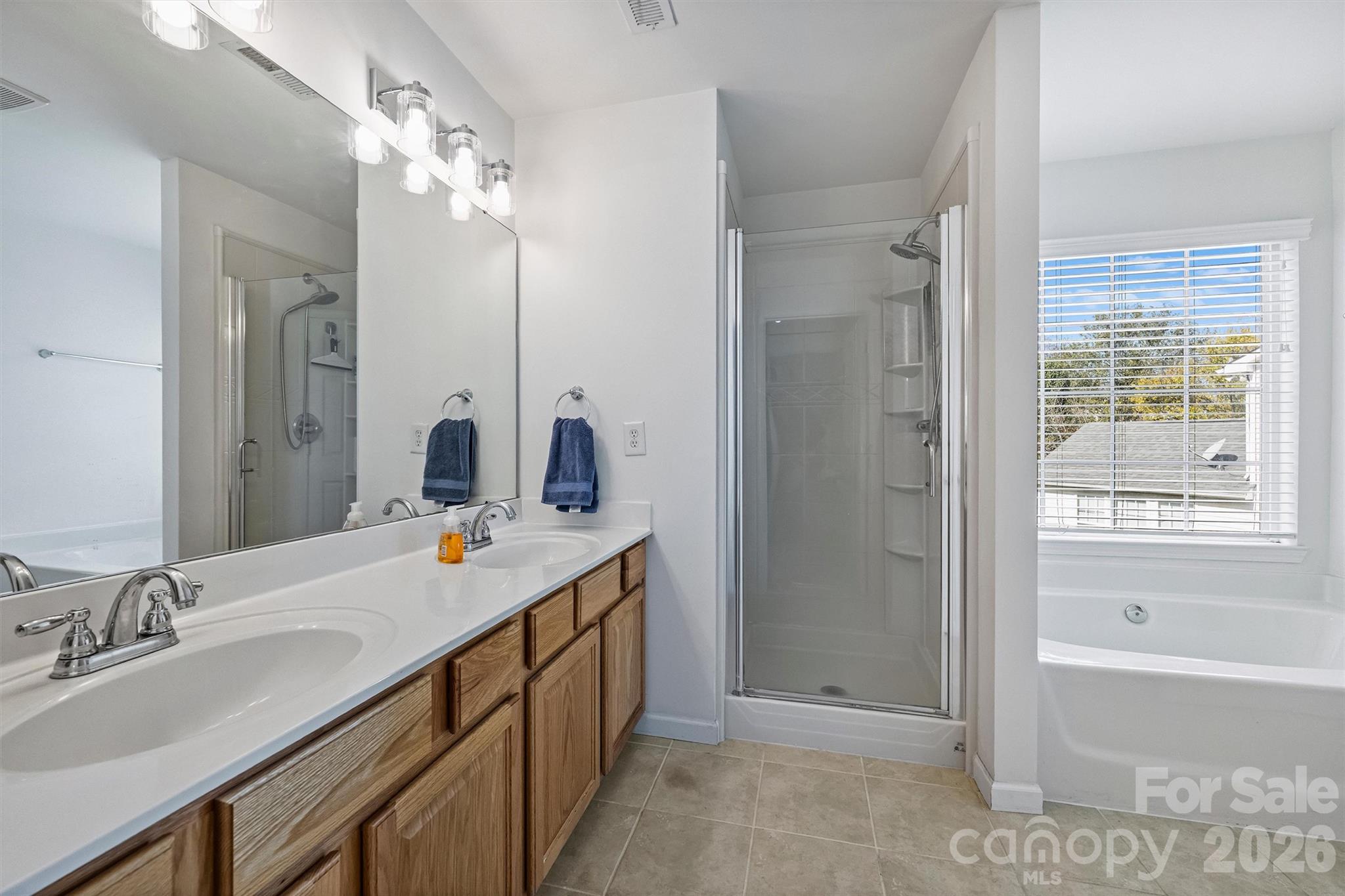 Primary bath with dual vanity, shower, and soaking tub. - 1006 Banaba Court, Indian Trail