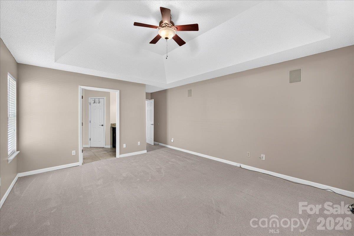 Large primary bedroom at the rear of the home, new carpet accessible doorway to bathroom and zero entry shower - 9115 Pine Springs Court, Huntersville