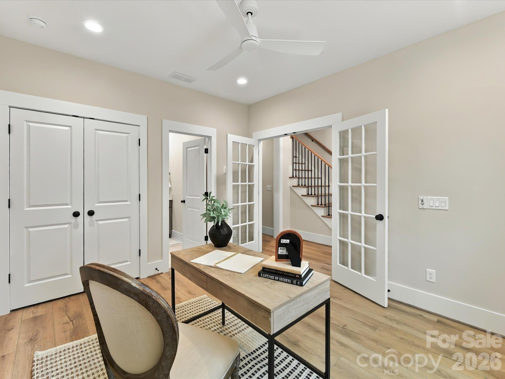 Versatile main-level office, bedroom or flex space featuring French doors, beautiful LVP, ample closet storage, and convenient access to a full bath. - 225 Davidson Gateway Drive, Davidson