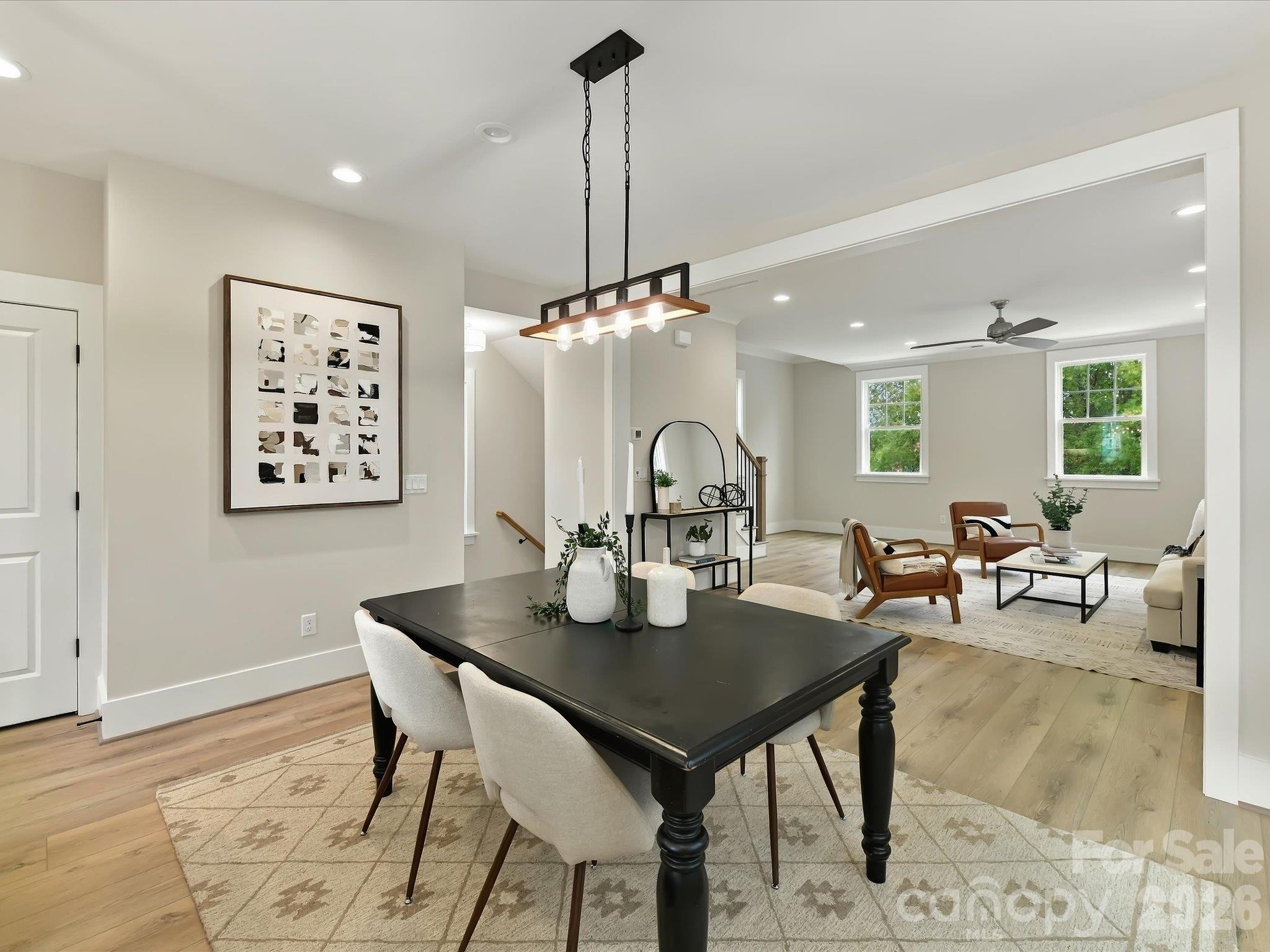 Elegant dining area featuring beautiful LVP flooring, modern statement lighting, and an open flow into the spacious kitchen and family room. - 225 Davidson Gateway Drive, Davidson