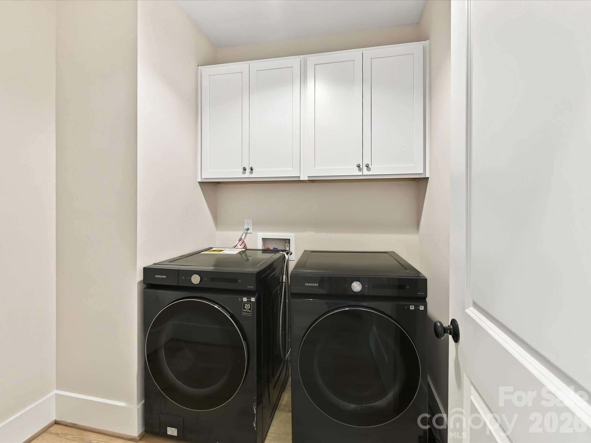 Convenient laundry room featuring overhead cabinetry and ample storage for everyday essentials. - 225 Davidson Gateway Drive, Davidson
