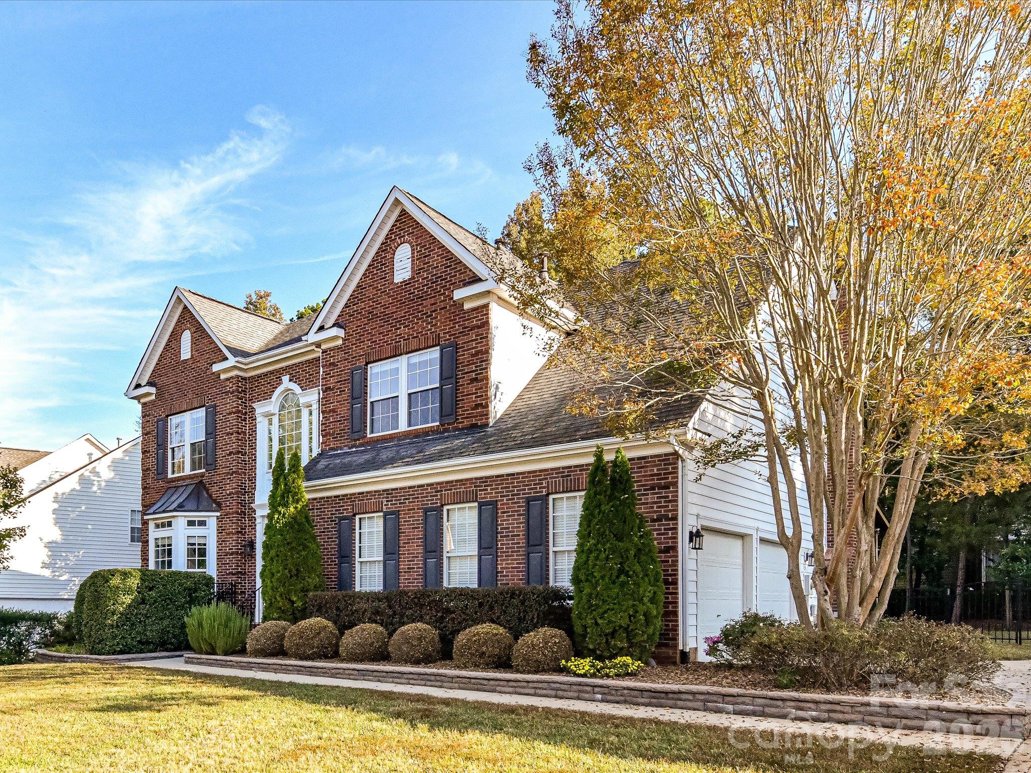 Beautiful two-story brick home featuring classic architectural details, a welcoming front door, elegant windows, and manicured landscaping. - 3819 Waters Reach Lane, Indian Trail