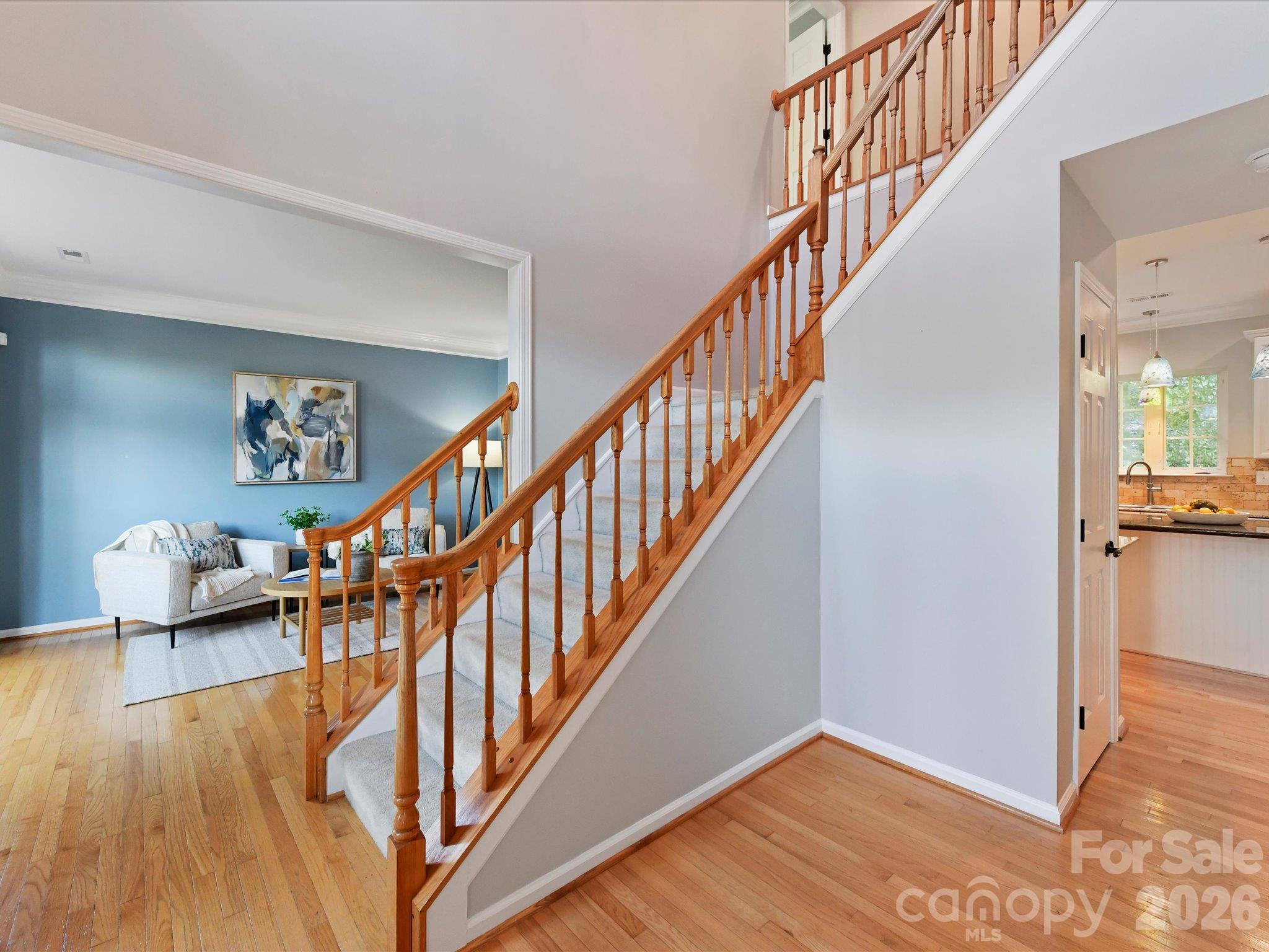 Beautiful staircase featuring warm wood railings, carpeted steps, and an open design connecting the main living areas. - 3819 Waters Reach Lane, Indian Trail