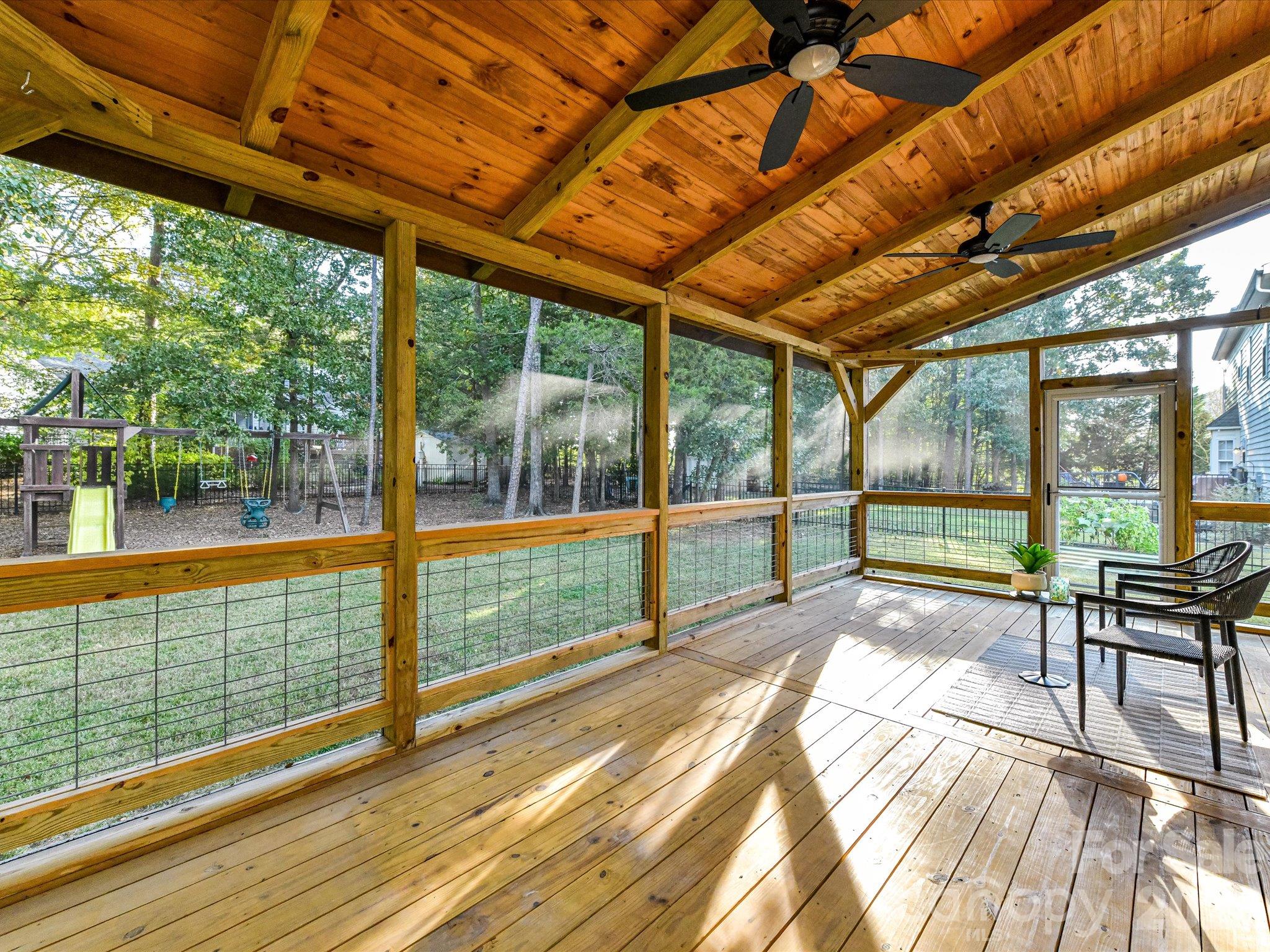 Inviting screened porch featuring a beautiful wood-paneled ceiling, ceiling fans, spacious seating area, and peaceful views of the backyard. - 3819 Waters Reach Lane, Indian Trail