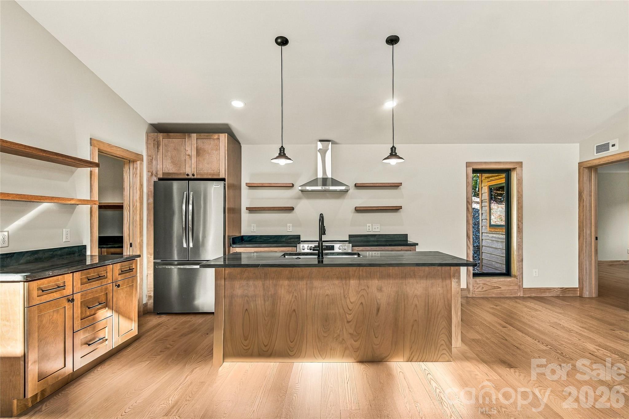 Beautifully appointed kitchen with quartzite countertops and custom cabinetry. - 205 Blue Moon Lane, Candler