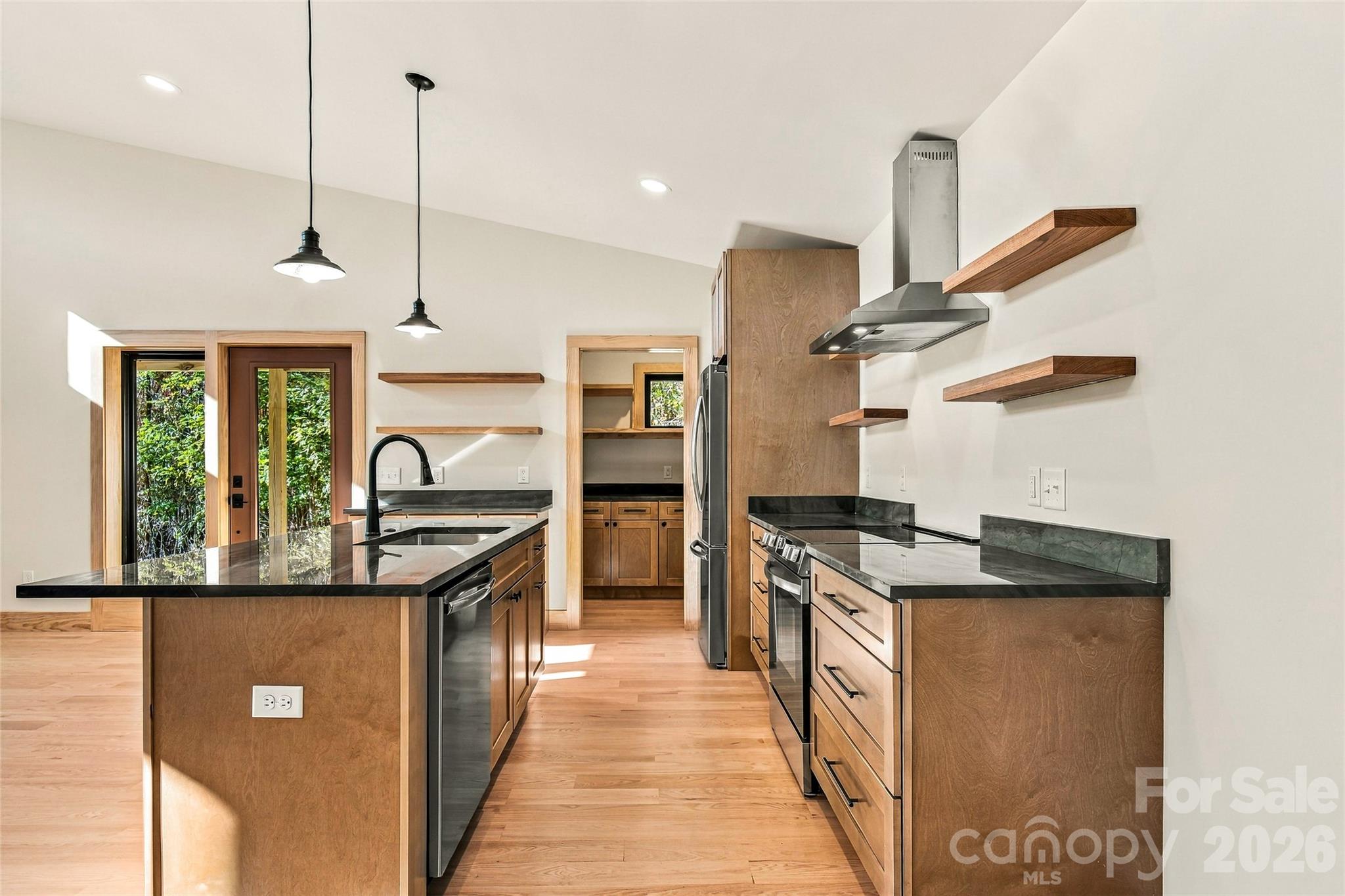 Thoughtful kitchen design with warm wood finishes and open shelving. - 205 Blue Moon Lane, Candler