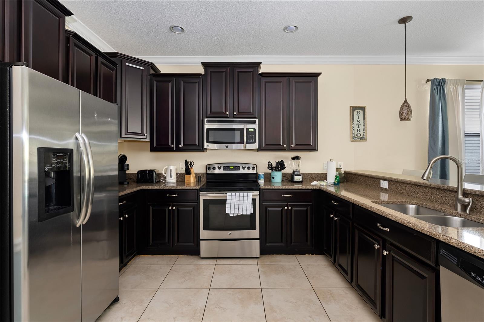 Spacious Kitchen Featuring Rich Espresso Cabinetry, Granite Countertops, Stainless Steel Appliances and Breakfast Bar Seating - 1520 MOON VALLEY DR, DAVENPORT