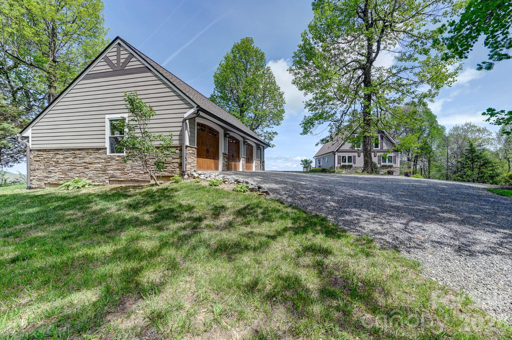 Warm weather view looking beyond the garage to the home - 107 Fawns Rest None, Black Mountain