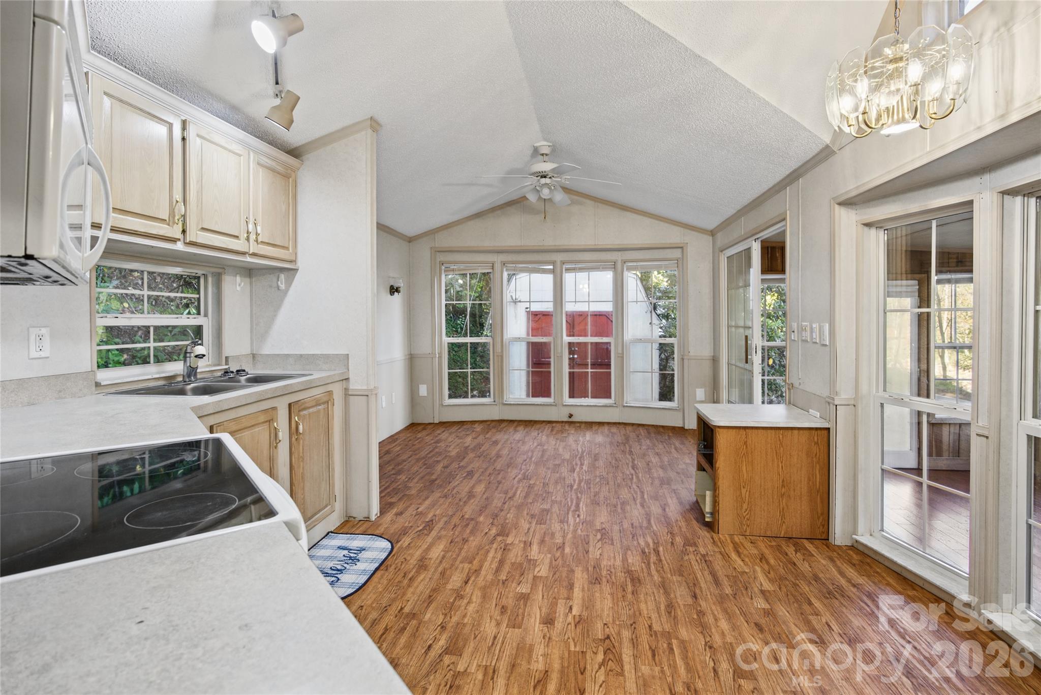 Open kitchen and living area with vaulted ceiling and natural light. - 13858 Cruso Road, Canton